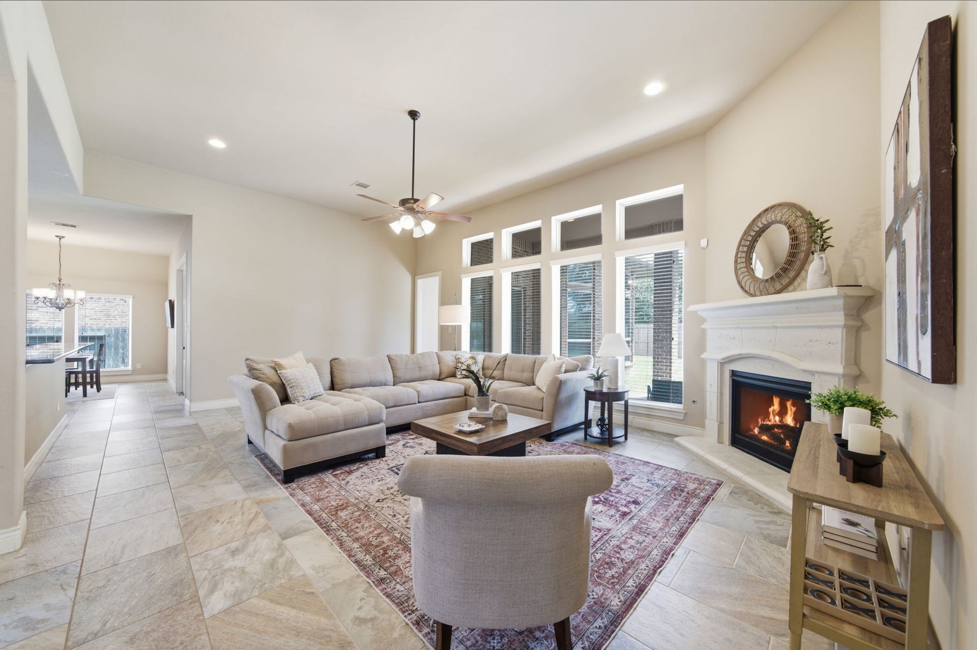 4603 Piper Shadow Lane, Katy, TX 77494 Spacious living room featuring a cozy fireplace, elegant tile flooring, and abundant natural light through large windows, perfect for relaxation and entertaining.