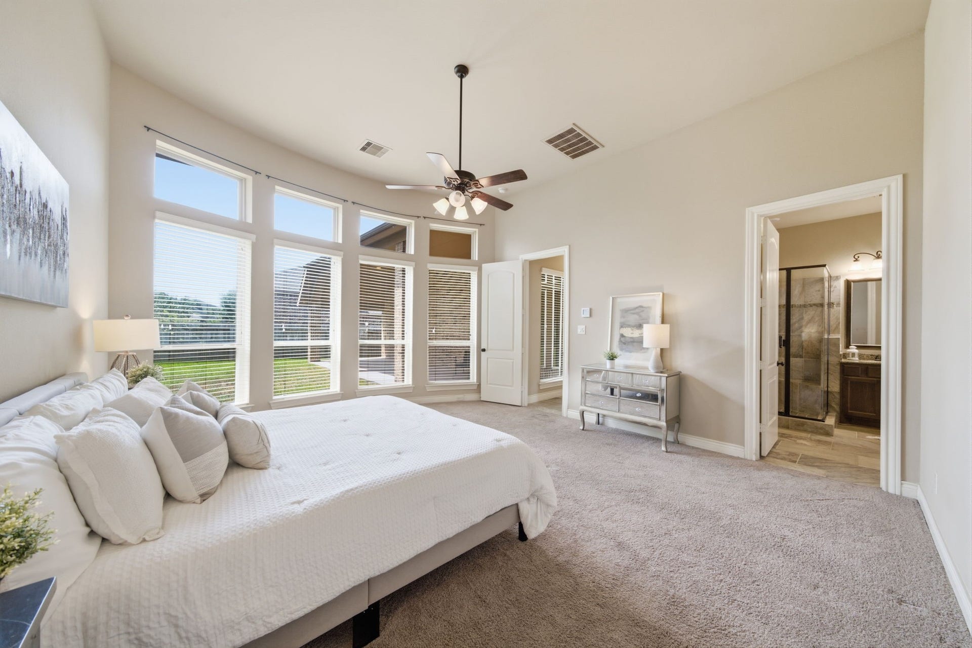 4603 Piper Shadow Lane, Katy, TX 77494 Spacious bedroom with abundant natural light from large windows, featuring a cozy carpeted floor and an ensuite bathroom with modern fixtures.
