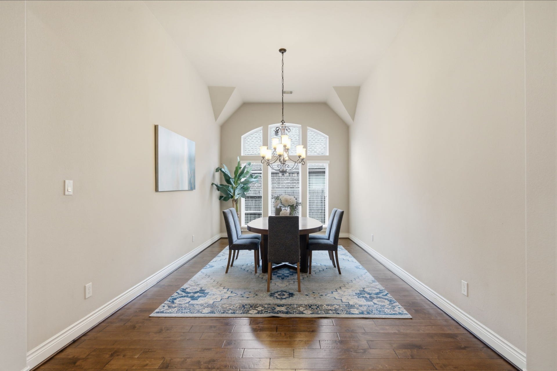 4603 Piper Shadow Lane, Katy, TX 77494 Elegant dining room with high ceilings, featuring a chic chandelier and abundant natural light from large windows, complemented by a stylish area rug and modern furnishings.