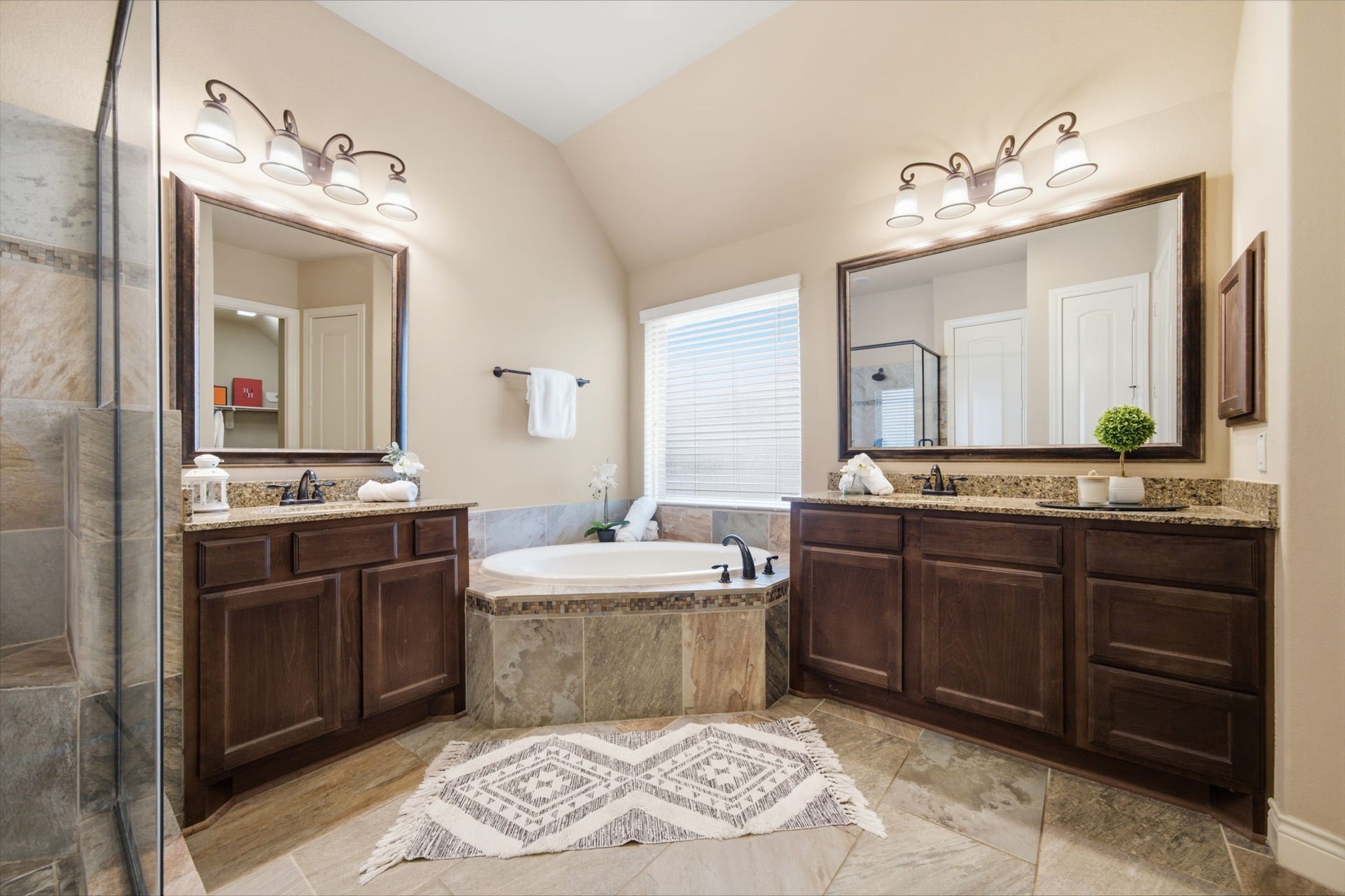 4603 Piper Shadow Lane, Katy, TX 77494 Luxurious bathroom featuring a spacious bathtub, dual vanities with granite countertops, elegant lighting, and a large glass-enclosed shower.