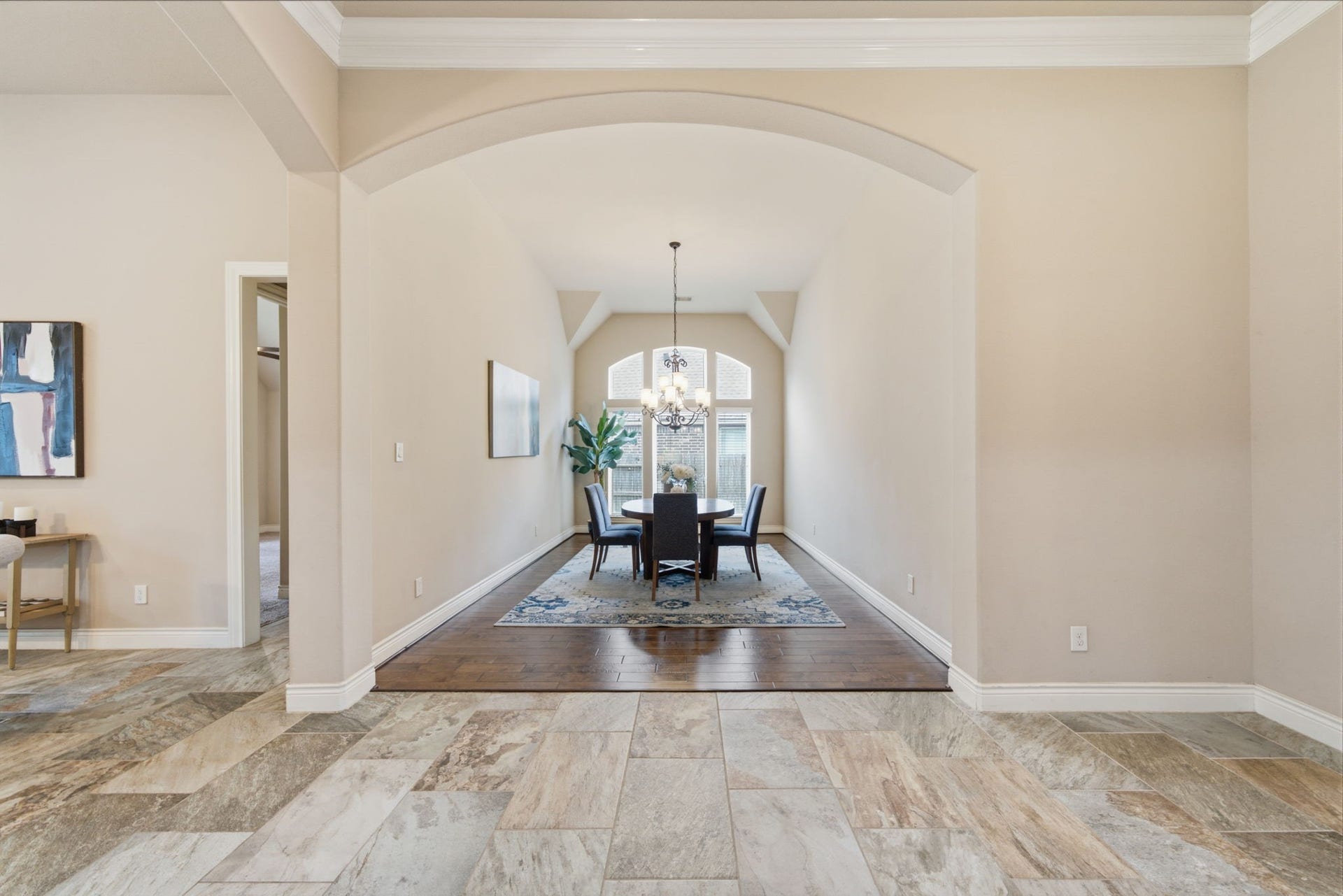 4603 Piper Shadow Lane, Katy, TX 77494 Elegant dining area with high ceilings and an arched entryway, featuring a stylish chandelier and natural light from large windows.