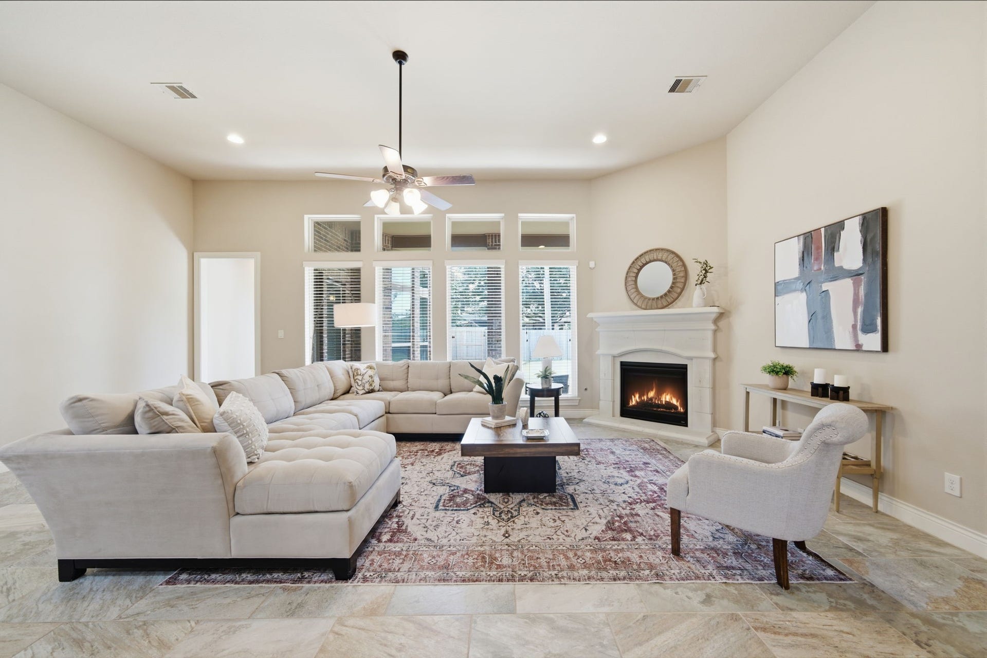 4603 Piper Shadow Lane, Katy, TX 77494 Spacious living room featuring a cozy fireplace, elegant tile flooring, and abundant natural light from large windows, creating a warm and inviting atmosphere.