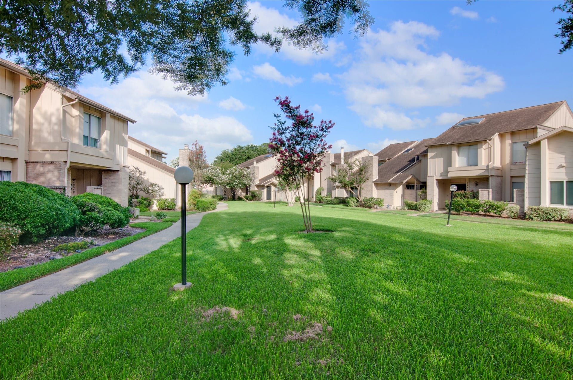 2916 Windchase Blvd, Houston, TX 77082 Charming townhomes with well-maintained landscaping and a serene, spacious green courtyard perfect for leisurely strolls.