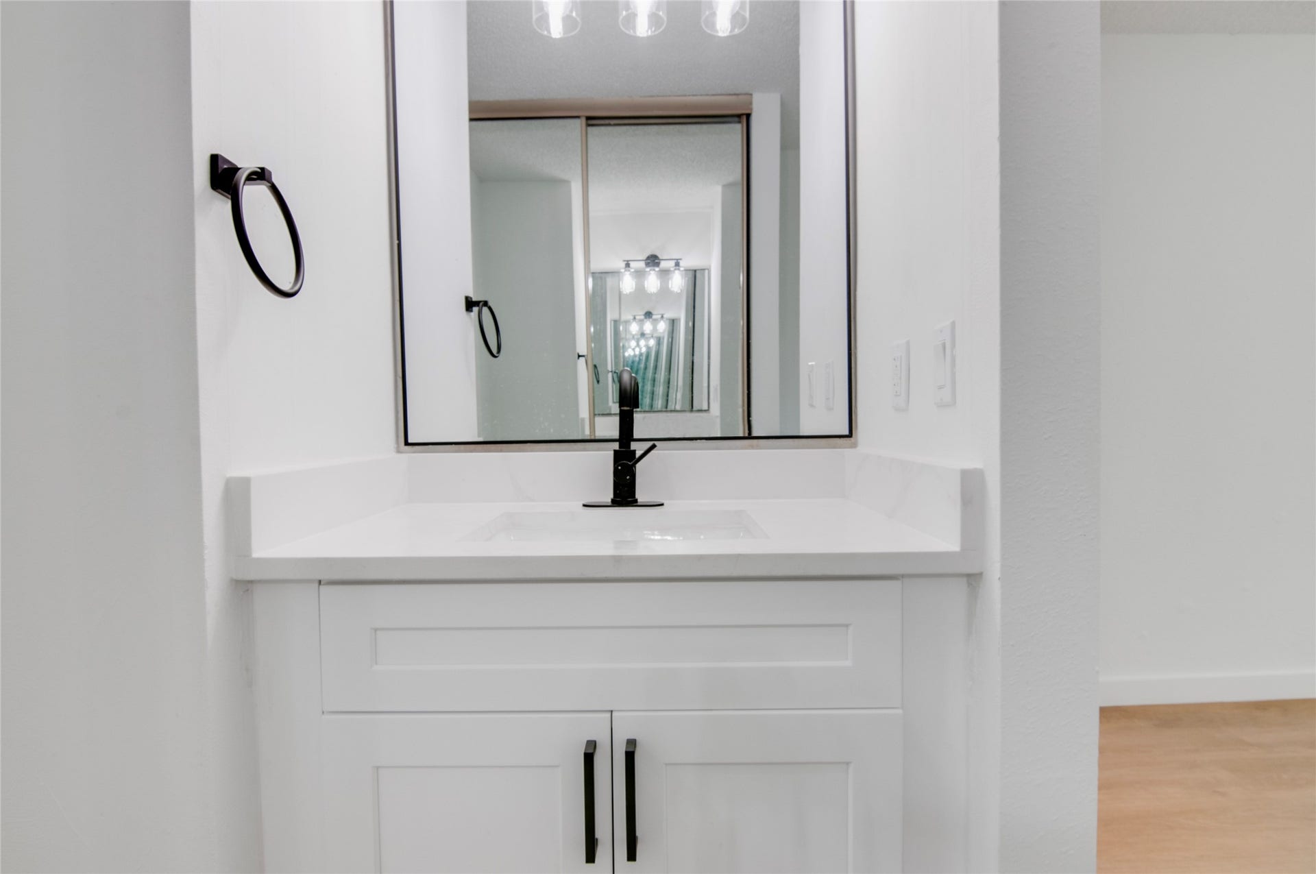 2916 Windchase Blvd, Houston, TX 77082 Modern bathroom vanity with a sleek white countertop, black fixtures, and a large mirror providing a bright, clean look.
