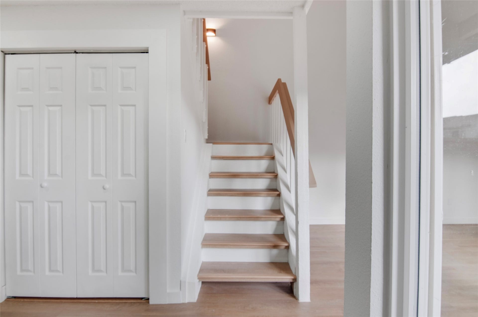 2916 Windchase Blvd, Houston, TX 77082 Bright and inviting staircase with elegant wood accents leads to the upper level, alongside a convenient closet with double doors, perfect for storage.