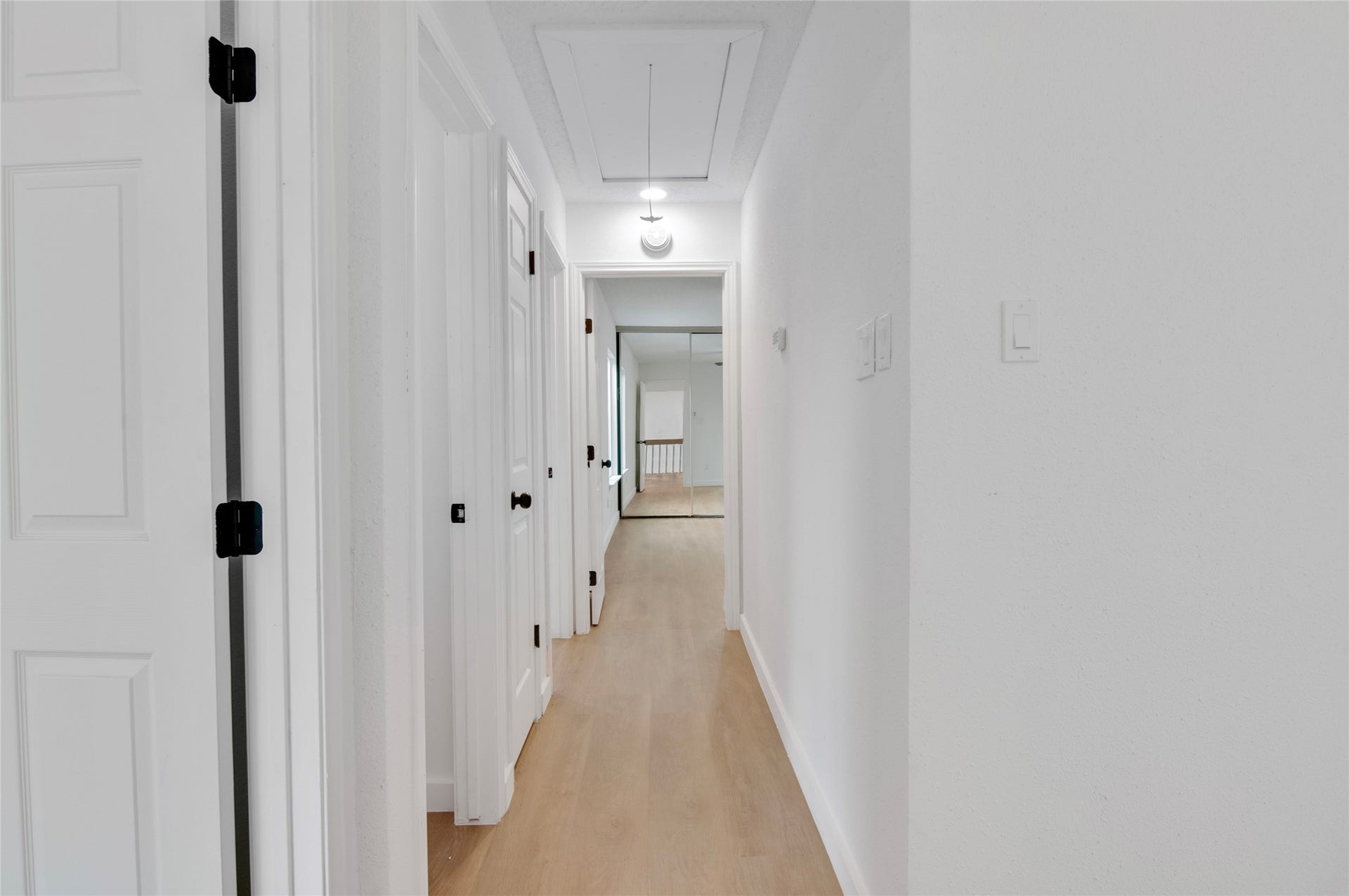 2916 Windchase Blvd, Houston, TX 77082 Bright and inviting hallway with light wood flooring and crisp white walls, leading to multiple rooms for easy access and flow.