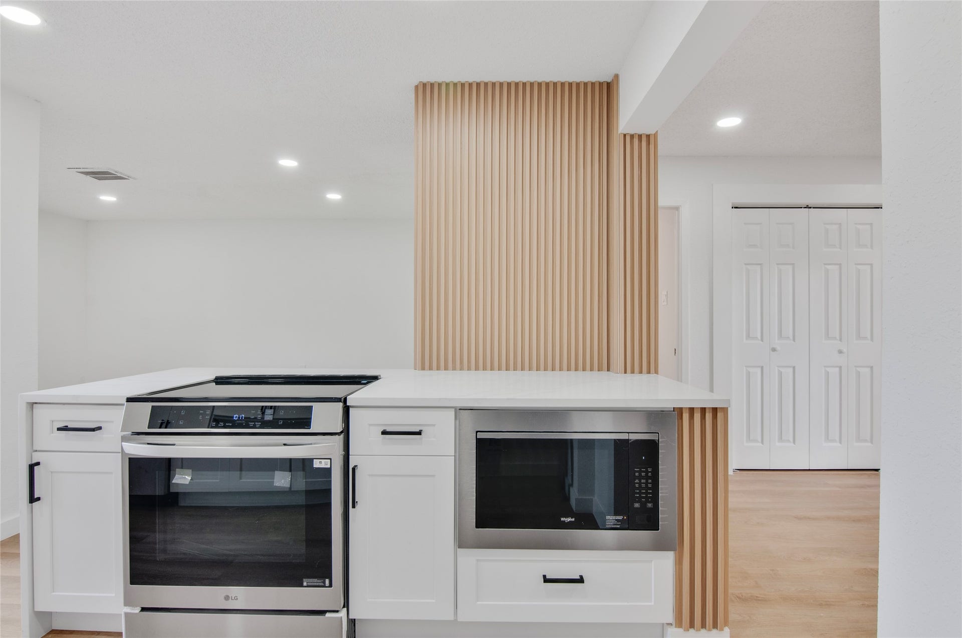 2916 Windchase Blvd, Houston, TX 77082 Modern kitchen featuring new stainless steel appliances, a stylish waterfall island, and elegant wood accents.