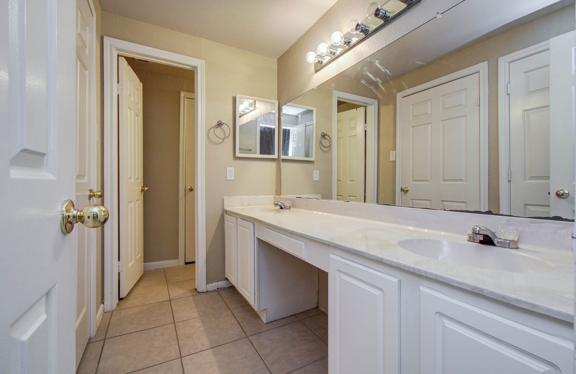 Bathroom features dual sinks, large mirror, and ample cabinet space.