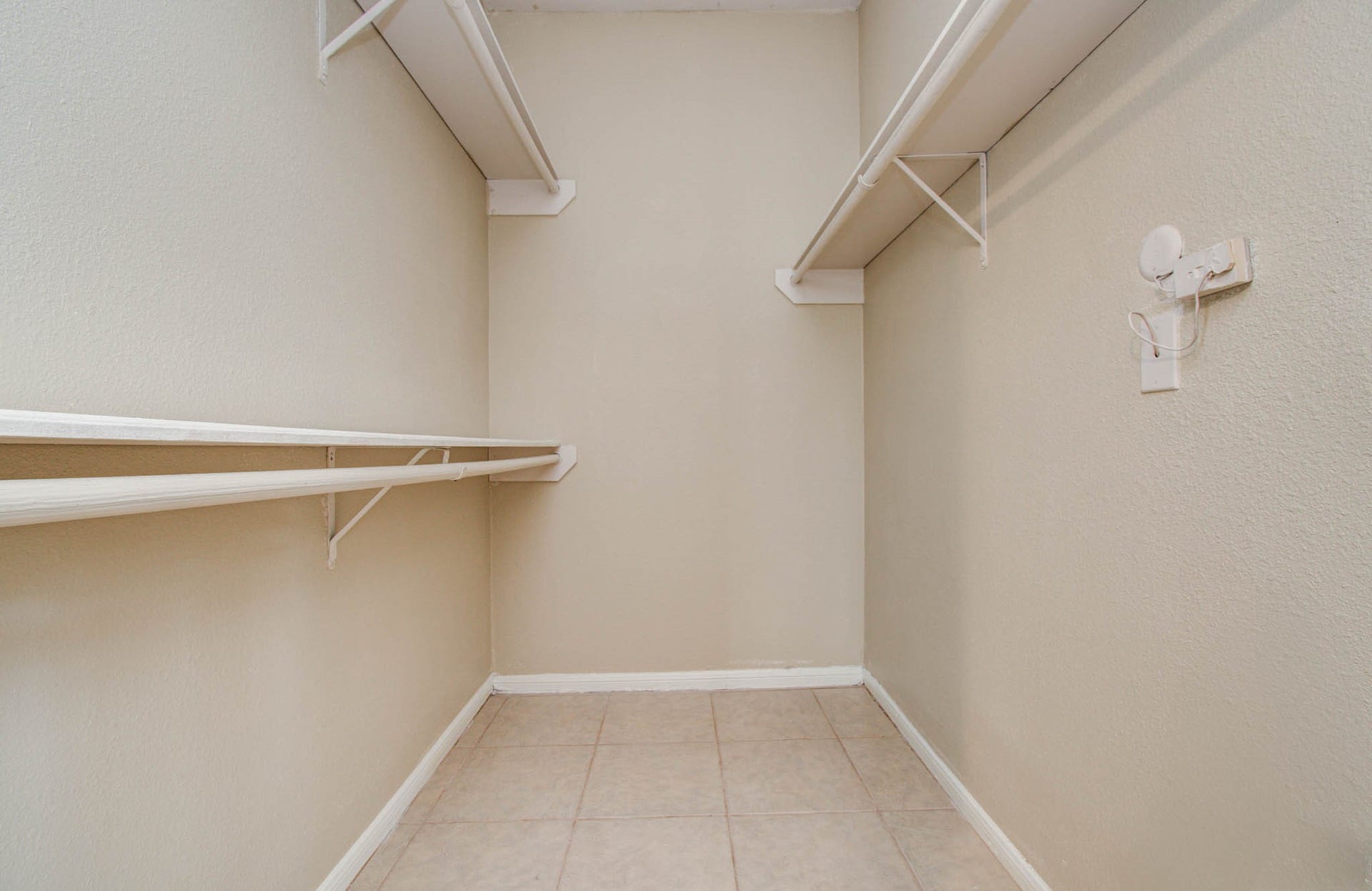 Bedroom features spacious walk-in closet with multiple shelves and hanging rods, offering ample storage space for clothing and accessories.
