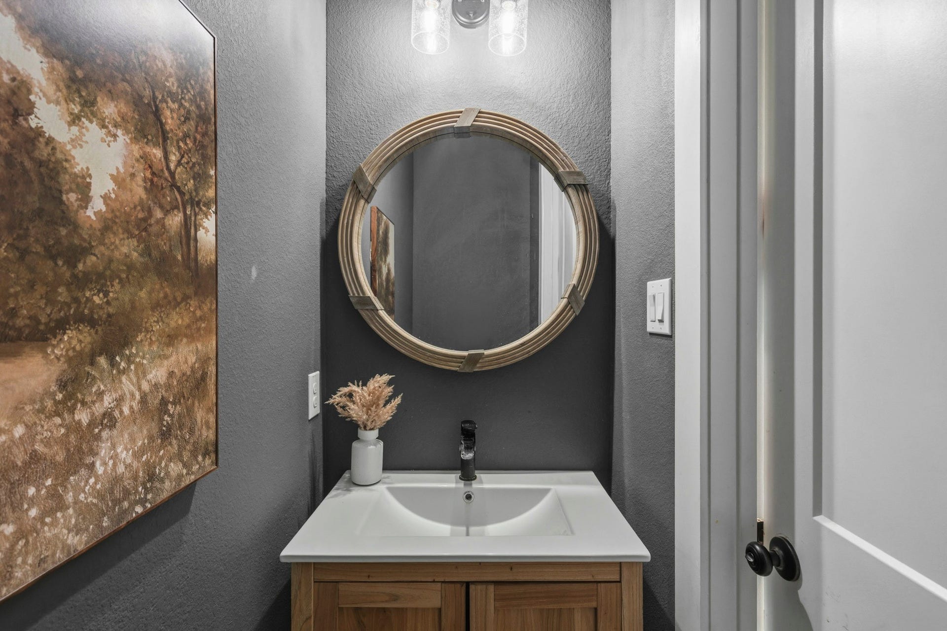 Conveniently located quietly off the Kitchen and Mud Room, the Powder Room is perfectly situated for guests and everyday use. This thoughtfully designed space features a pedestal sink, a custom framed mirror and designer paint.