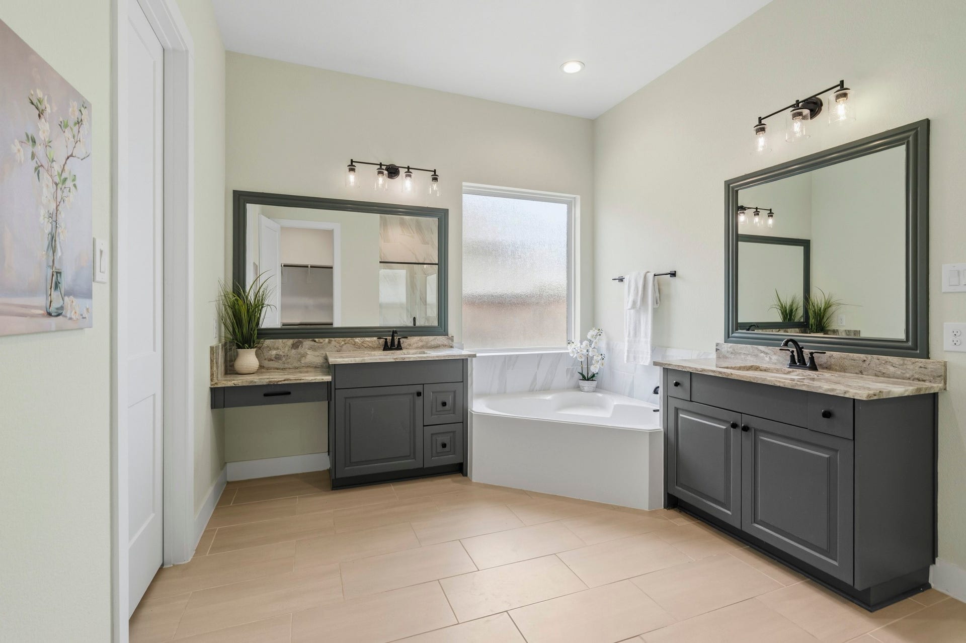 The Primary Bath exudes sophistication and timeless style, offering a spa like experience for daily relaxation. Thoughtfully appointed with dual vanities, a dedicated makeup vanity, and bathed in beautiful granite with under-mount sinks, custom framed mirrors and black cabinet hardware where every day detail has been carefully curated to blend luxury with functionality.
