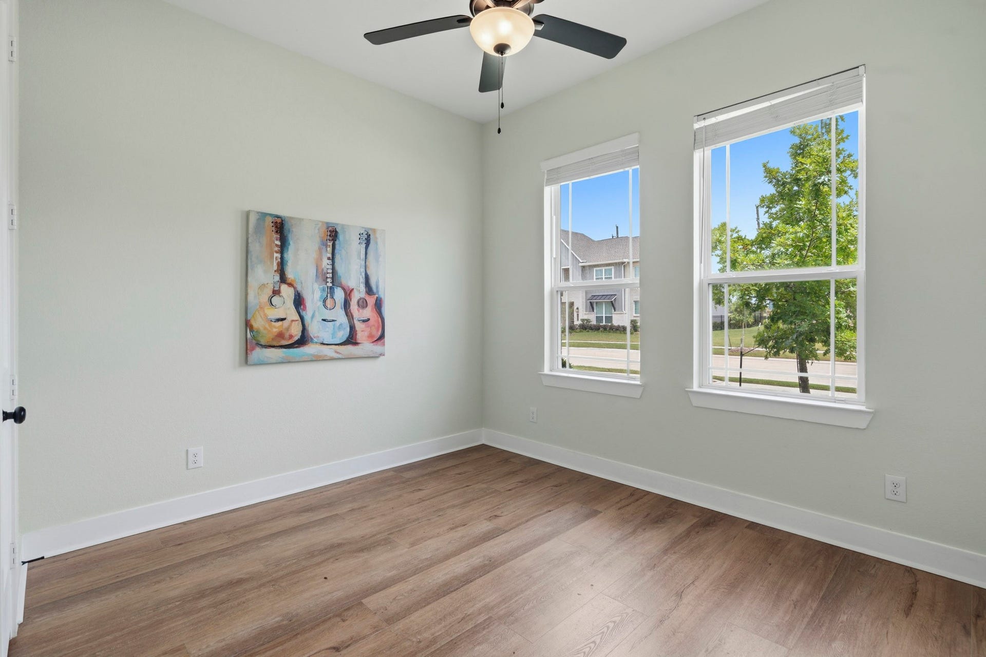 This light-filled Secondary Bedroom offers a warm and inviting space, featuring beautiful LVP flooring, two front yard-facing windows and a spacious walk-in closet for ample storage. Conveniently located down the hall, this room shares a centrally positioned Full Bath with another Bedroom.
