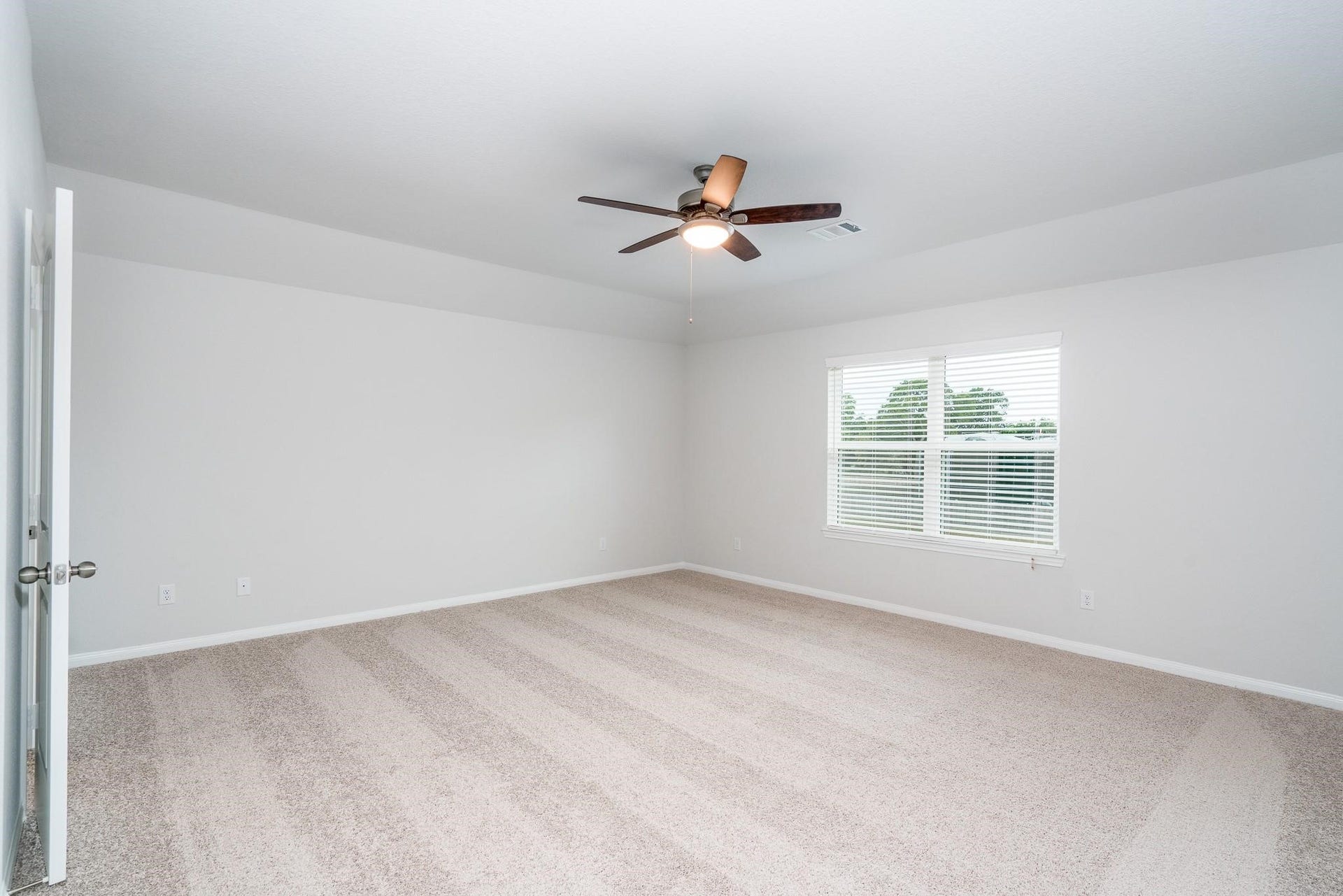 2910 Orchid Ranch Drive, Katy, TX 77494 Spacious bedroom featuring plush carpeting, a ceiling fan, and large window for natural light.