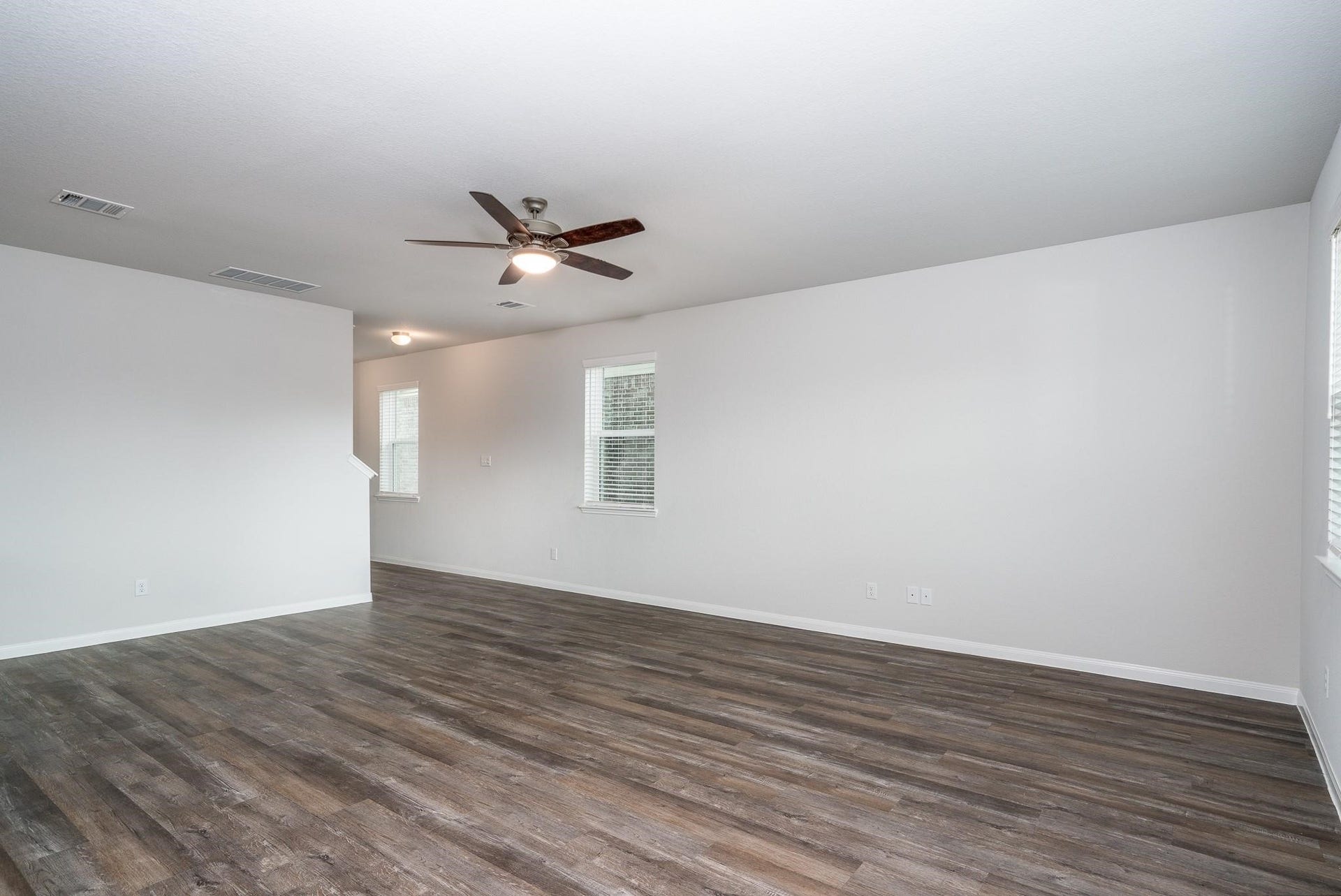2910 Orchid Ranch Drive, Katy, TX 77494 Spacious living area with sleek hardwood floors, abundant natural light, and modern ceiling fan, ideal for comfortable living and entertaining.