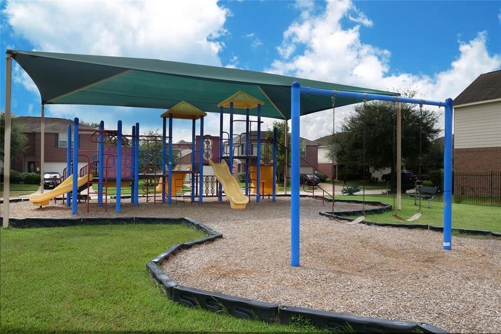 2910 Orchid Ranch Drive, Katy, TX 77494 Charming neighborhood playground featuring vibrant play structures, swings, and a shaded canopy, perfect for family fun and outdoor activities.