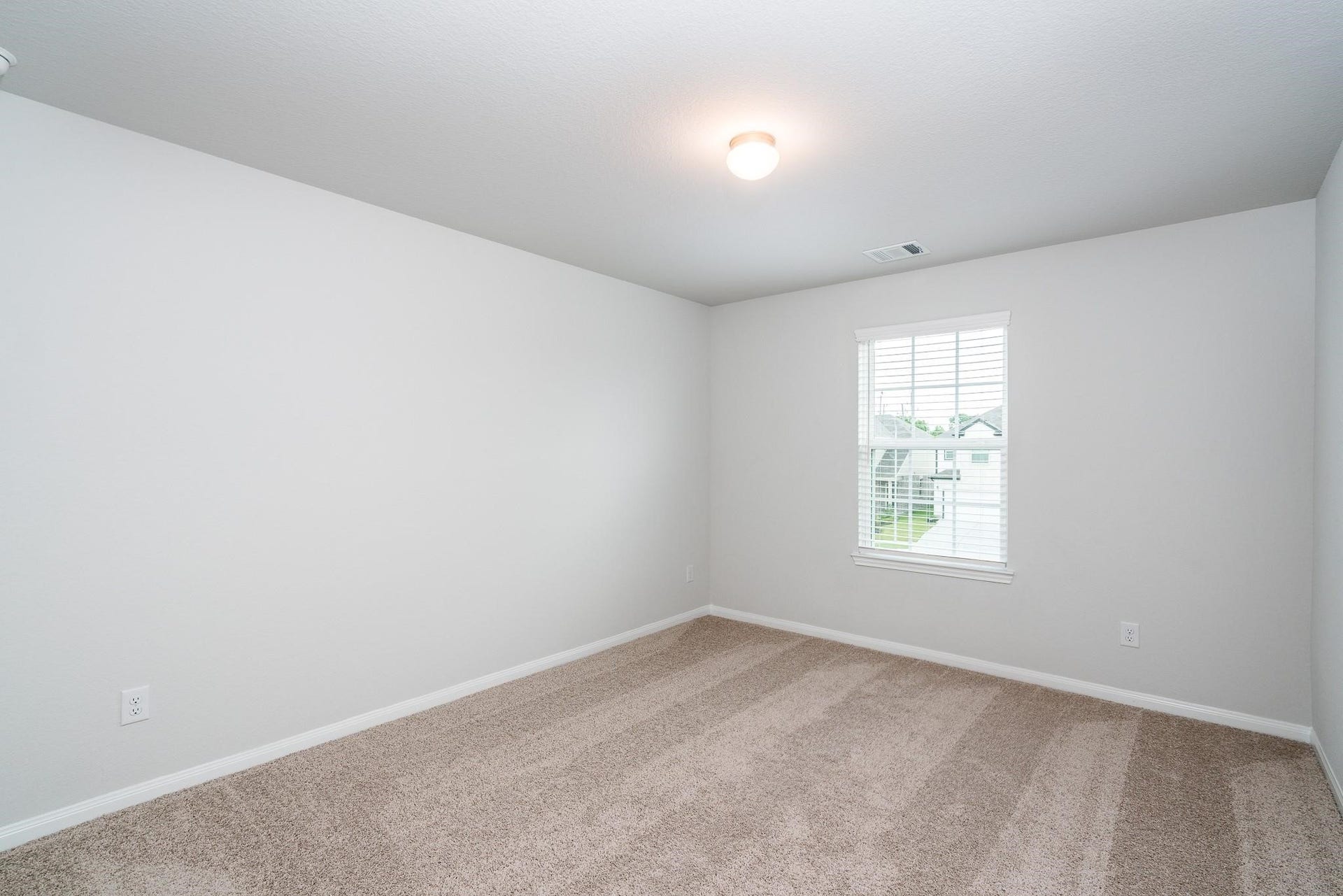 2910 Orchid Ranch Drive, Katy, TX 77494 Bright and airy bedroom featuring soft carpet flooring, neutral walls, and a large window for natural light.