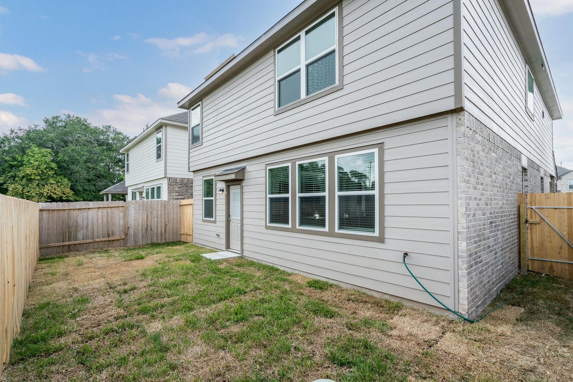 2910 Orchid Ranch Drive, Katy, TX 77494 Charming two-story home with a fenced backyard, perfect for outdoor activities and privacy. The exterior features a combination of brick and siding, complemented by ample windows for natural light.