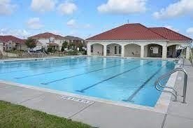 2910 Orchid Ranch Drive, Katy, TX 77494 Enjoy resort-style living with a spacious swimming pool and elegant clubhouse, ideal for relaxation and gatherings.