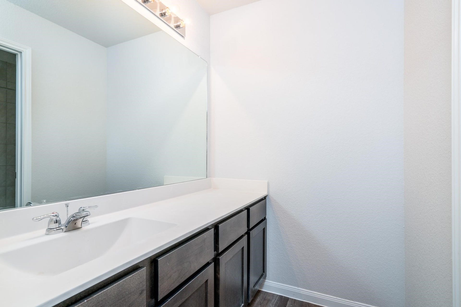 2910 Orchid Ranch Drive, Katy, TX 77494 Modern bathroom with a sleek vanity, large mirror, and elegant lighting, offering a bright and inviting space.