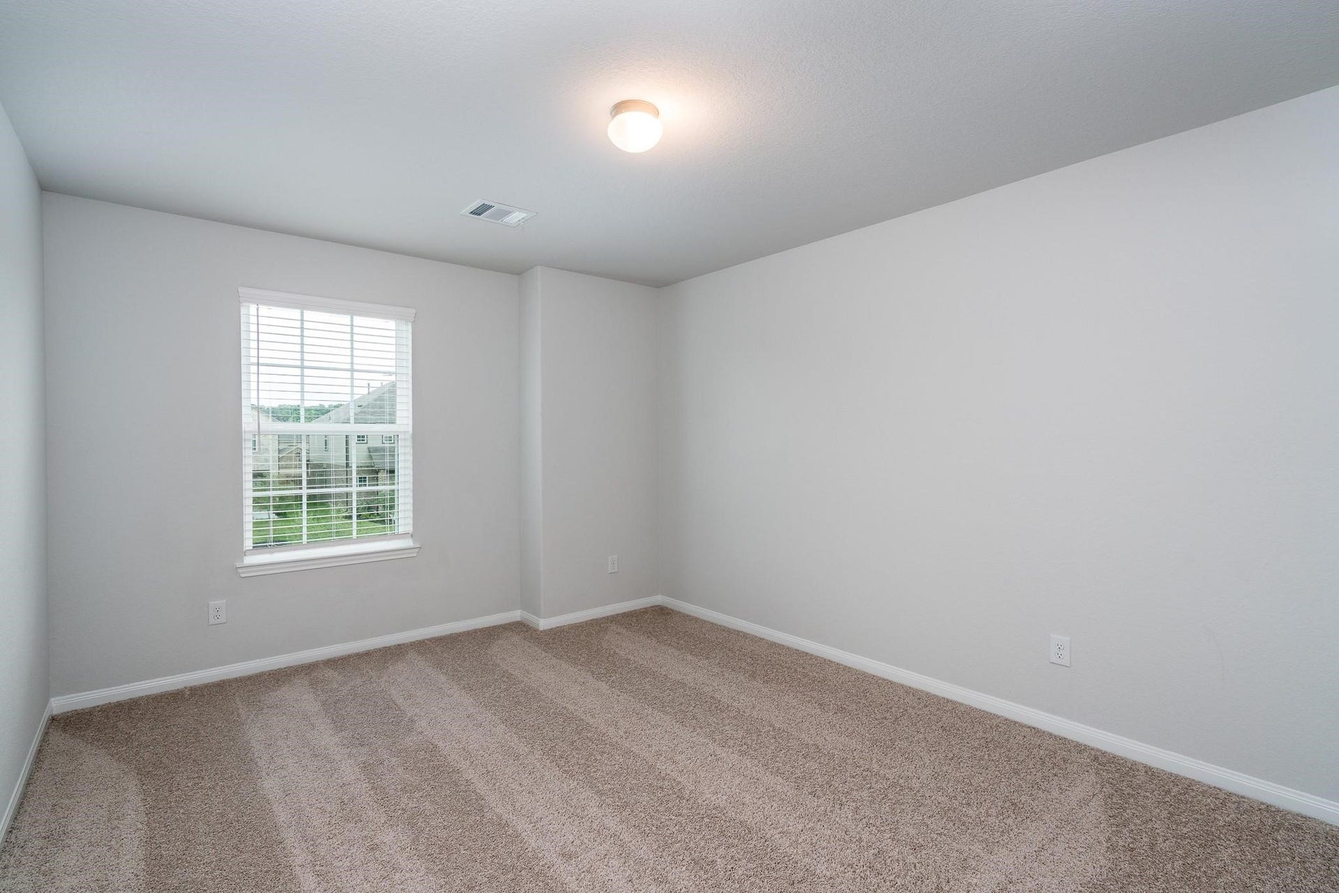 2910 Orchid Ranch Drive, Katy, TX 77494 Bright and inviting bedroom with soft carpeting, neutral walls, and a large window offering natural light and a view of the outdoors.