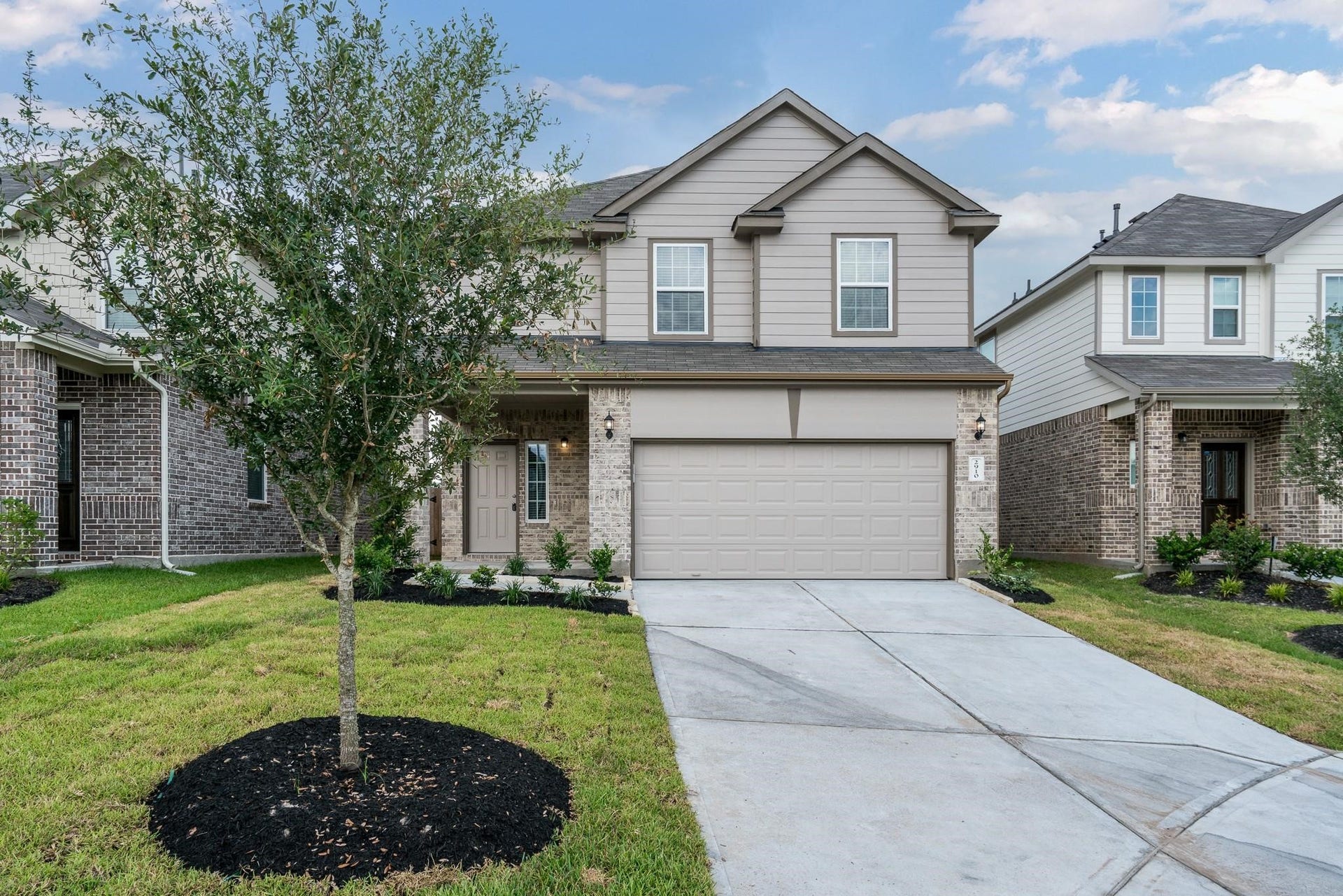2910 Orchid Ranch Drive, Katy, TX 77494 Charming two-story home with a contemporary facade, featuring a double garage and a welcoming front porch, set amidst a manicured lawn and mature tree.