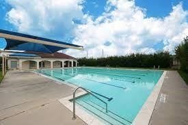2910 Orchid Ranch Drive, Katy, TX 77494 Enjoy sunny days by this expansive outdoor pool, featuring a shaded area and surrounded by lush landscaping for privacy and relaxation.
