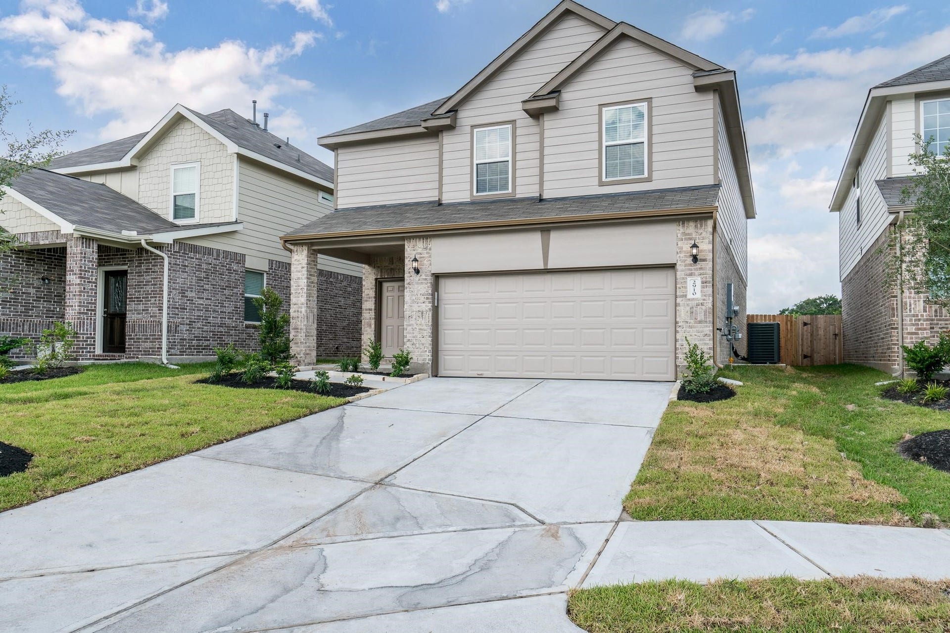 2910 Orchid Ranch Drive, Katy, TX 77494 Modern two-story home with a spacious two-car garage and charming brick accents, nestled in a quiet neighborhood with well-maintained landscaping.