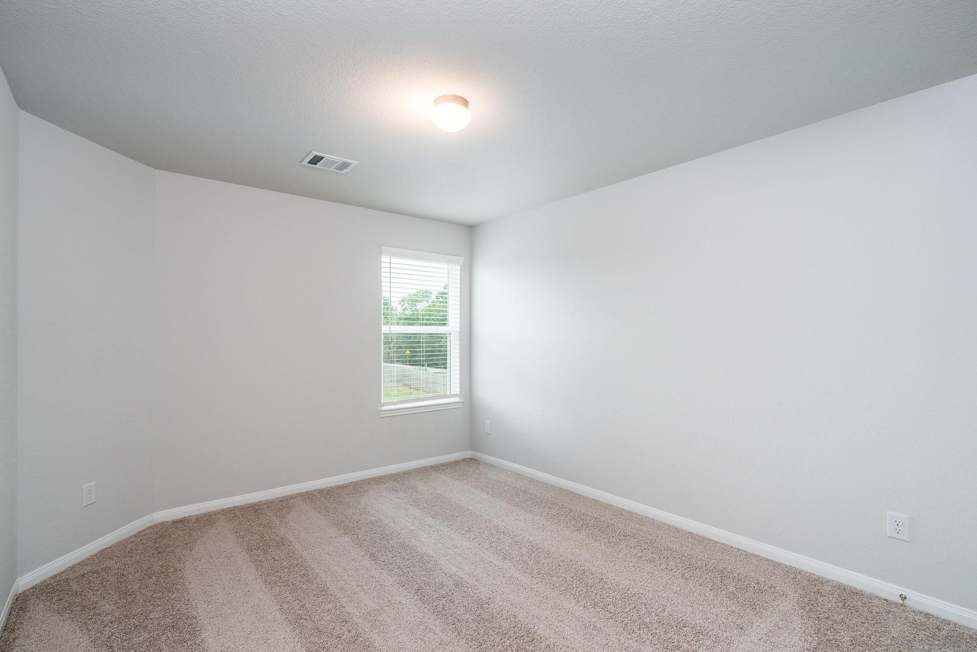 2910 Orchid Ranch Drive, Katy, TX 77494 Bright and airy bedroom featuring plush carpet, a large window for natural light, and neutral walls perfect for any decor style.