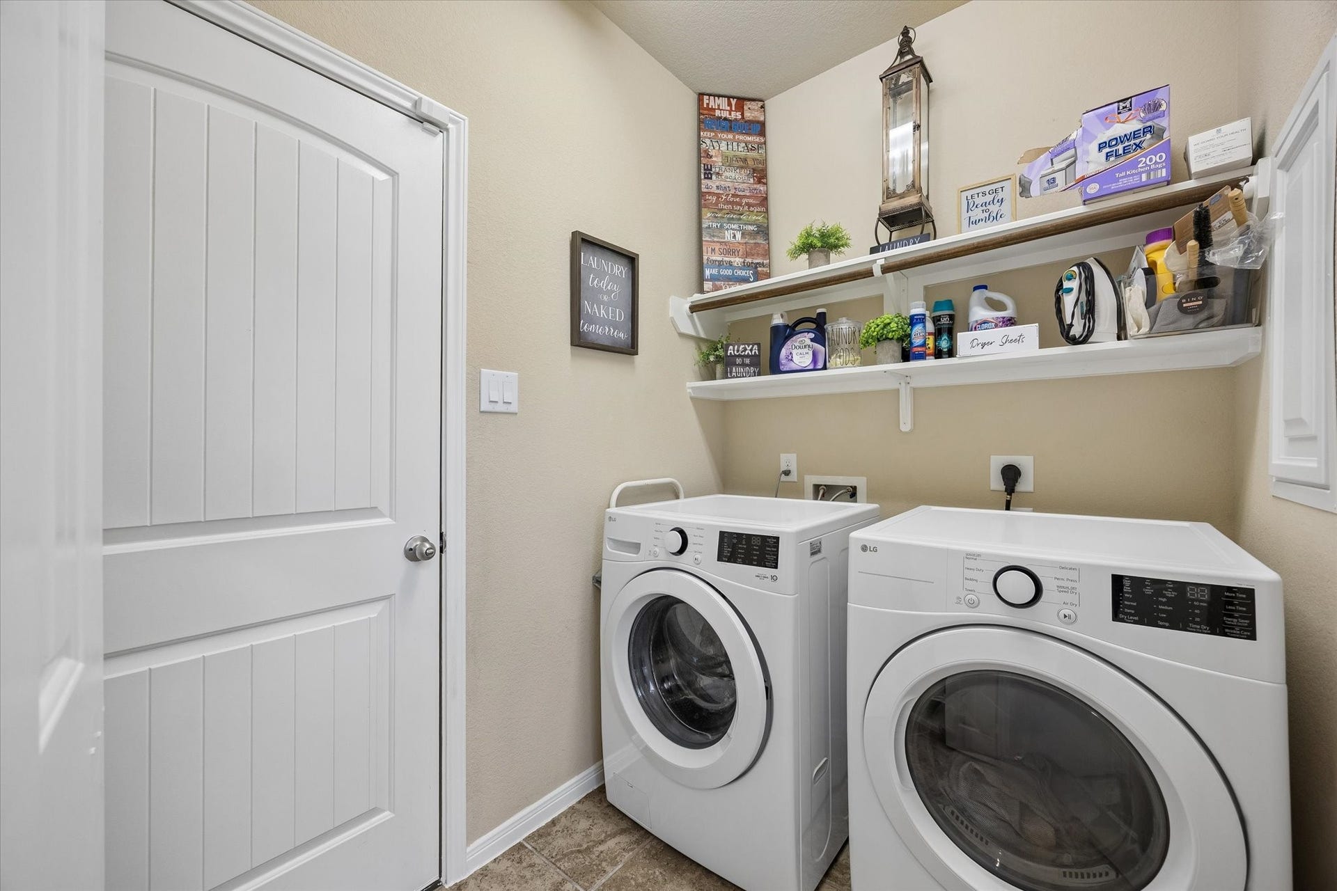 Dedicated utility room with built-in shelving and space for full sized washer and dryer