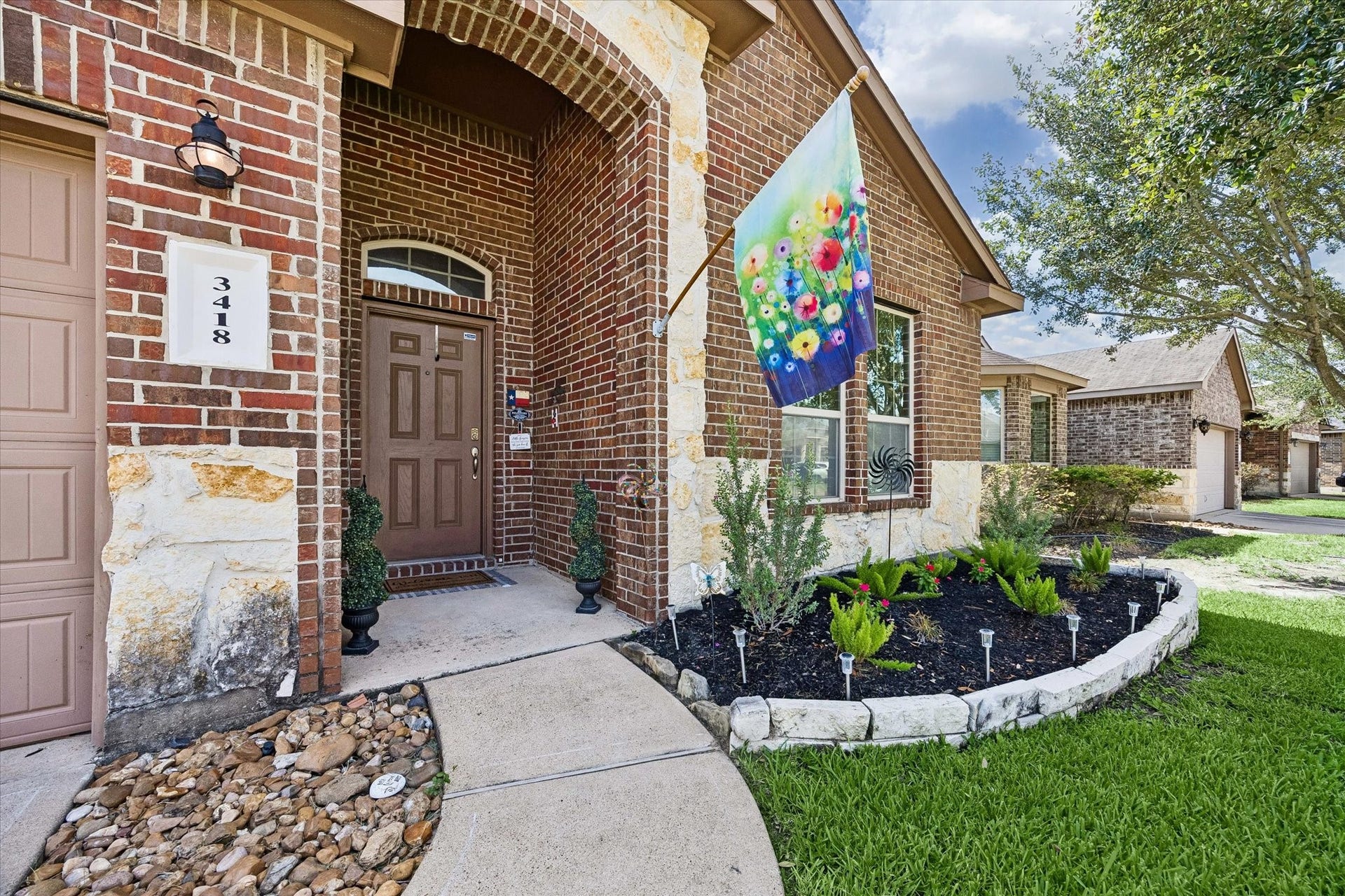 Welcoing covered entry with mature landscaping