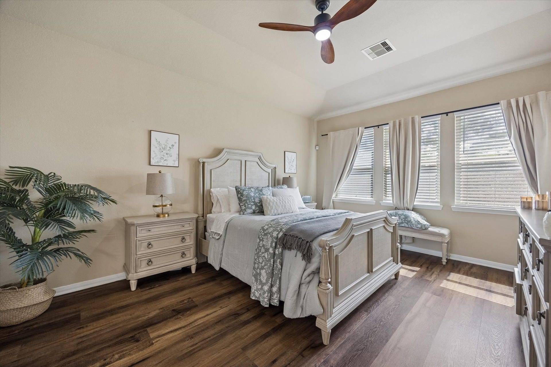 Spacious primary bedroom with large windows and LVP flooring