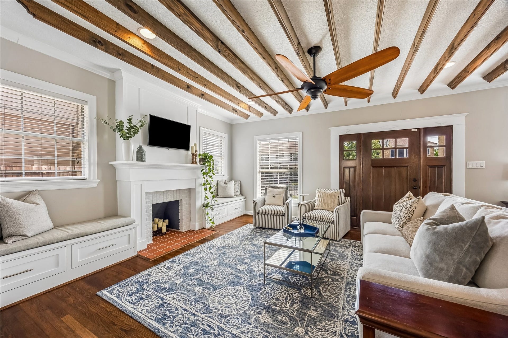 1909 Rosewood Street, Houston, TX 77004 Natural light pours into the living room from multiple sides, highlighting the fireplace, detailed ceiling beams, and classic millwork.