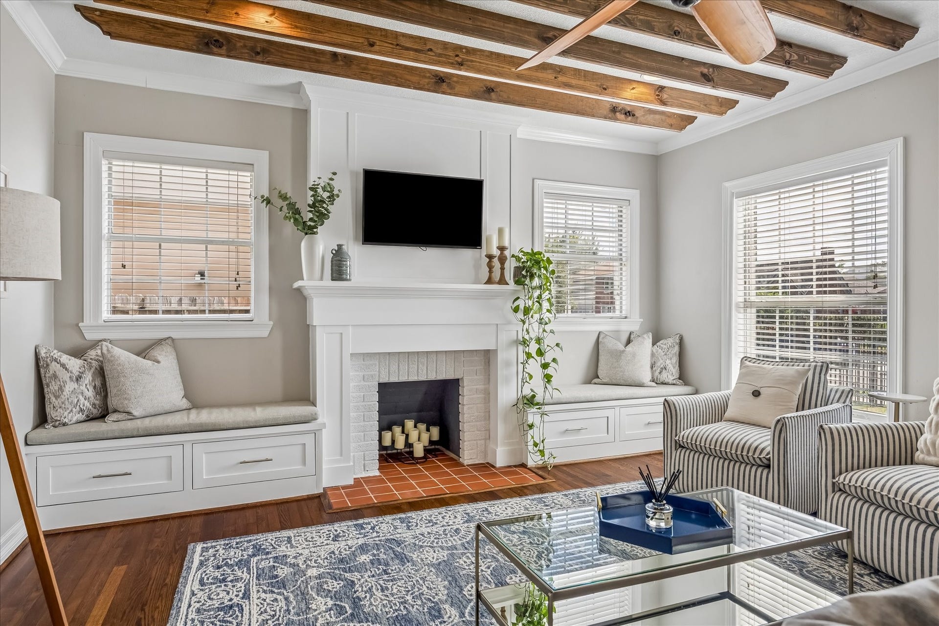 1909 Rosewood Street, Houston, TX 77004 Exposed ceiling beams, a centered fireplace, and built-in window seating give the living room plenty of character, with cabinetry and benches upgraded in 2022.