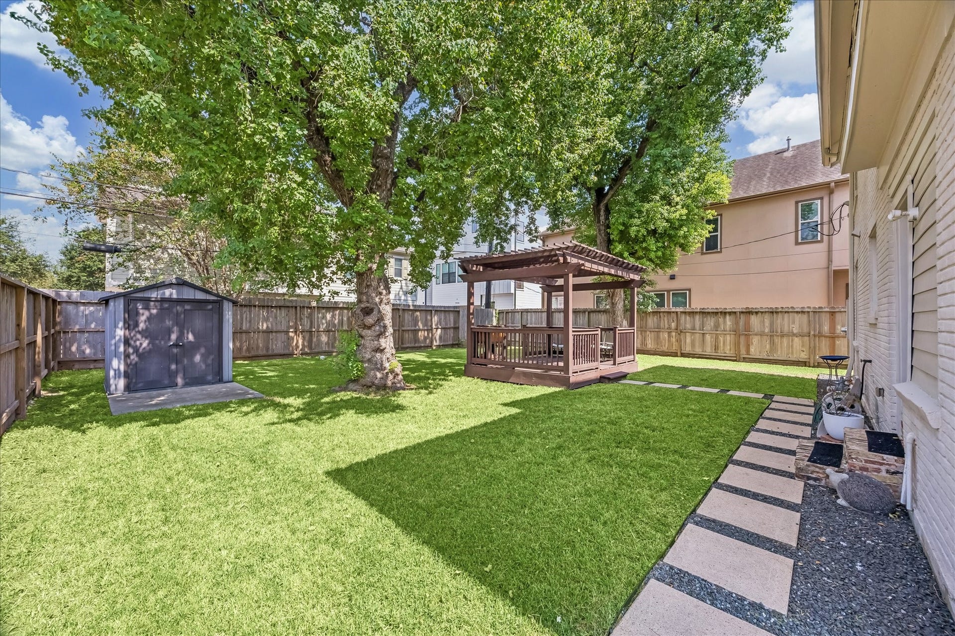 1909 Rosewood Street, Houston, TX 77004 Fenced backyard pairs open lawn with a paver walkway installed in 2020, along with French drainage added the same year.