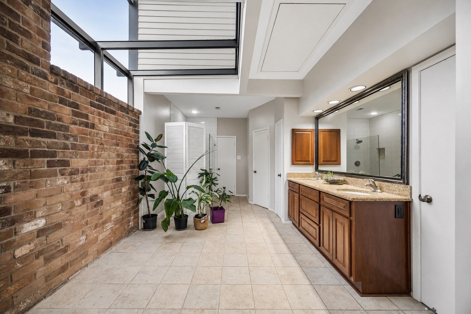 3902 Crystal Falls Drive, Missouri City, TX 77459 Unique primary bath featuring dual vanities and dramatic skylight.