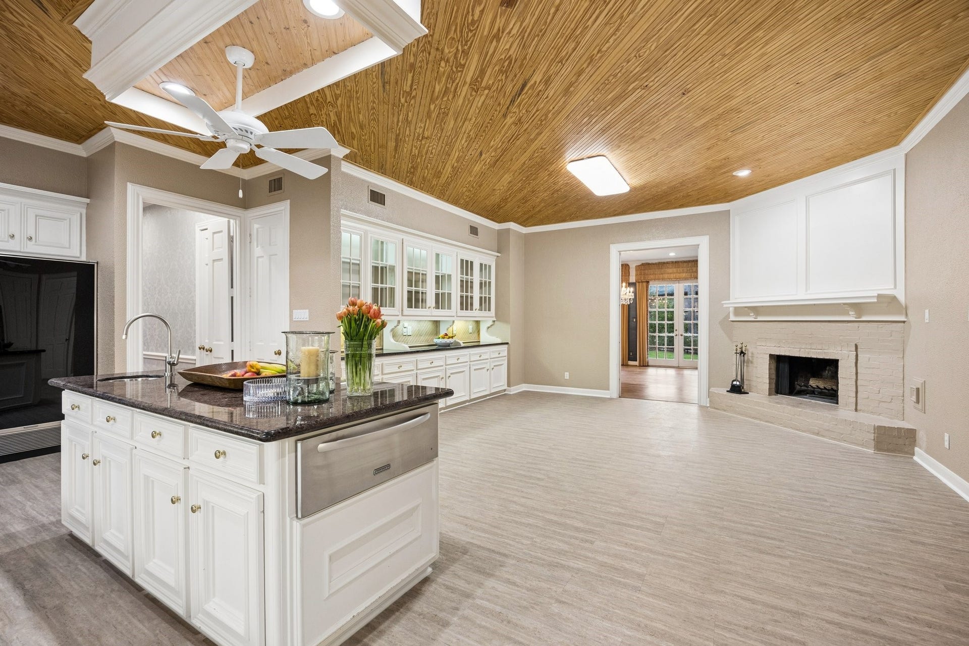 10 Stillforest Street, Piney Point Village, TX 77024 The well-appointed cooking area showcases a gas cooktop with a decorative tile backsplash and a charming gas-log fireplace serving as a warm architectural focal point.