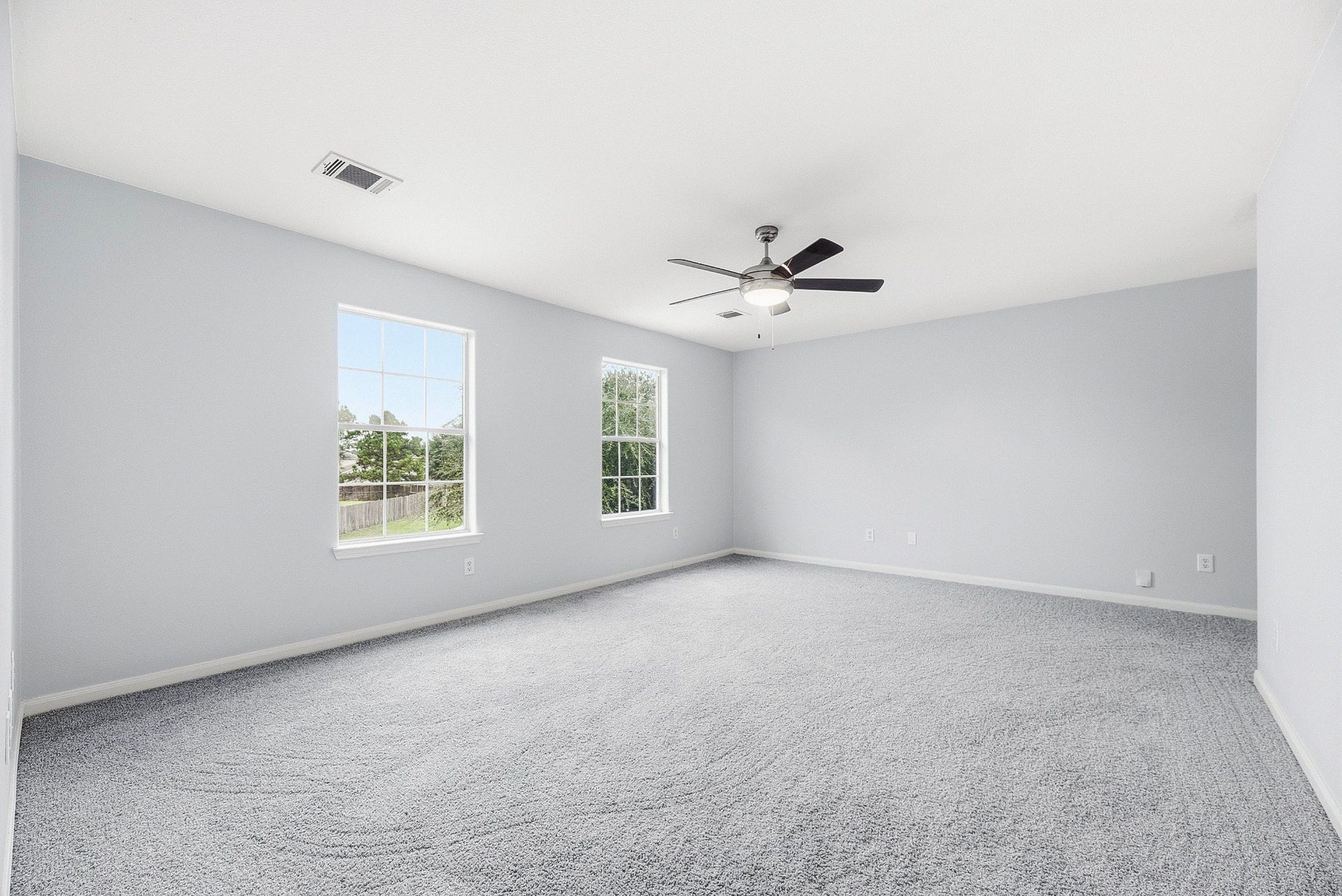 28838 Frio River Loop, Spring, TX 77386 Paired windows illuminate the primary bedrooms carpeted floor and softly toned walls.