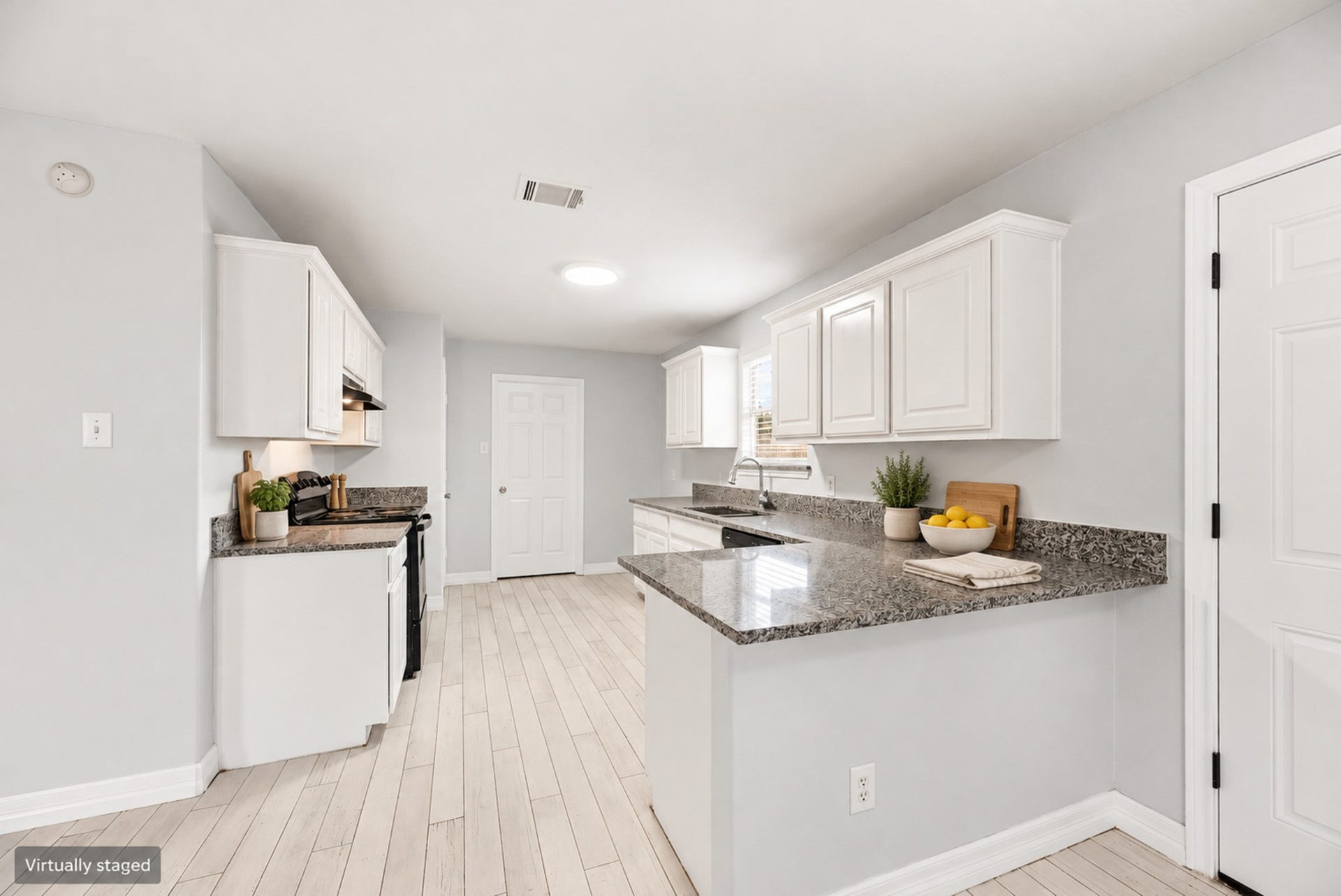 28838 Frio River Loop, Spring, TX 77386 White cabinetry, patterned counters, and black appliances create a coordinated kitchen with peninsula workspace. (Virtually staged)