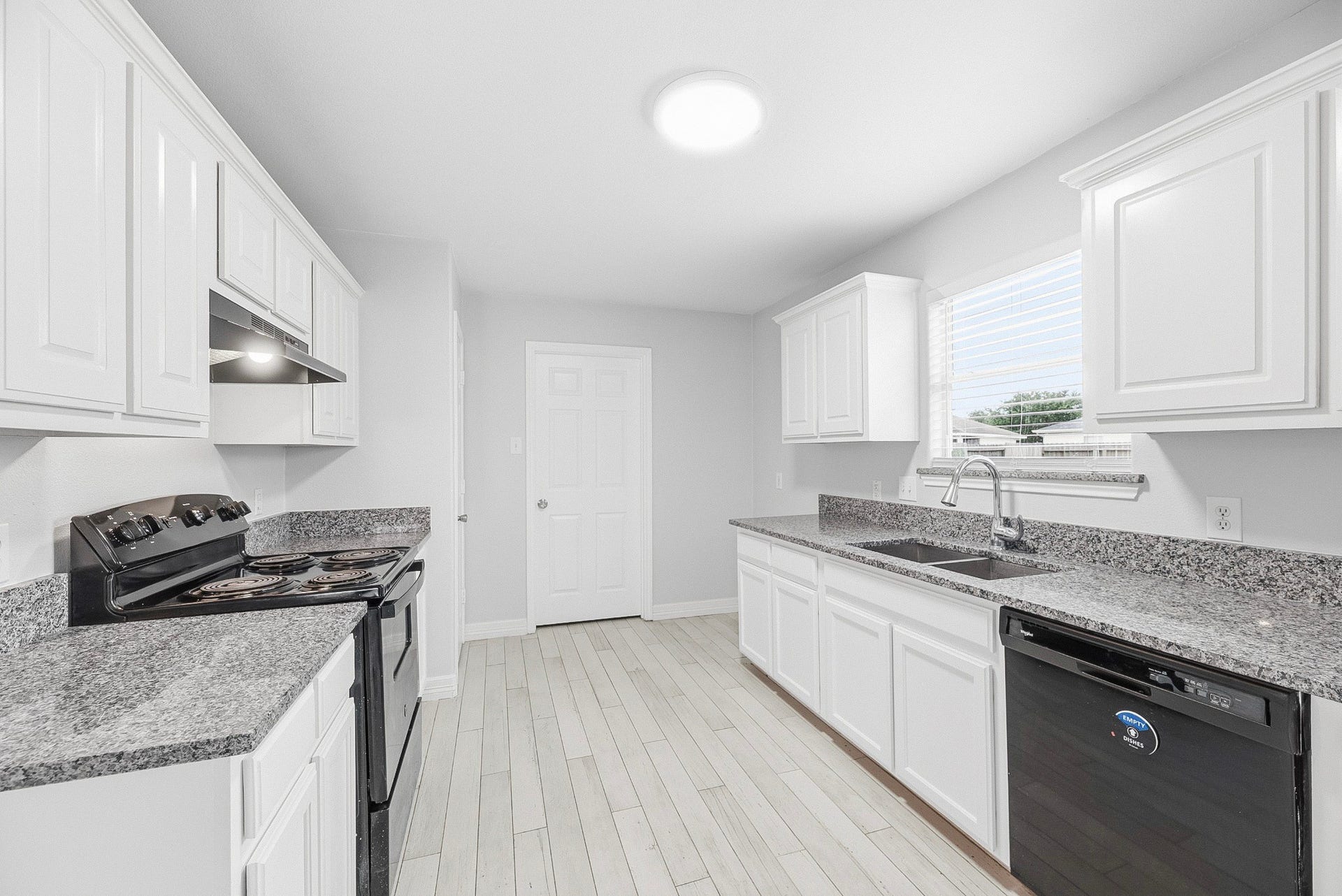 28838 Frio River Loop, Spring, TX 77386 A central kitchen aisle connects the electric range, sink, dishwasher, and surrounding cabinetry.