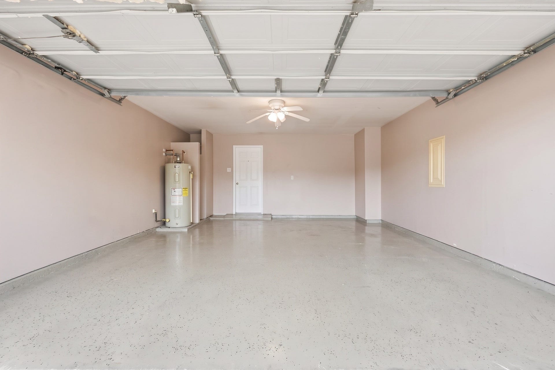 28838 Frio River Loop, Spring, TX 77386 Attached garage features a speckled floor finish, overhead door, and interior access.