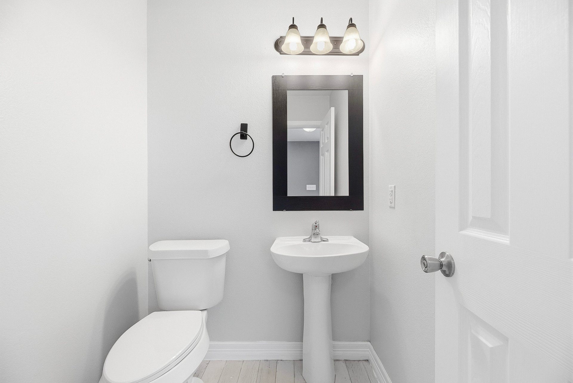 28838 Frio River Loop, Spring, TX 77386 Powder room features a pedestal sink, framed mirror, and coordinated neutral finishes.