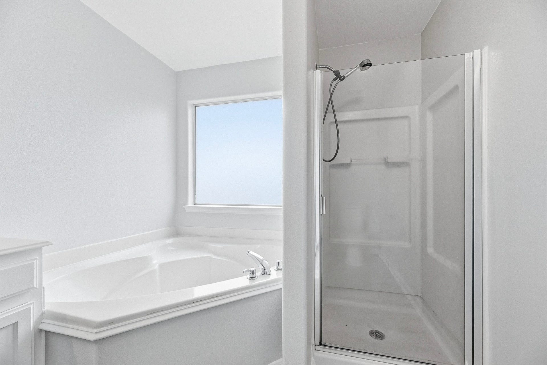 28838 Frio River Loop, Spring, TX 77386 A corner soaking tub and separate shower offer distinct bathing areas beneath a privacy window.