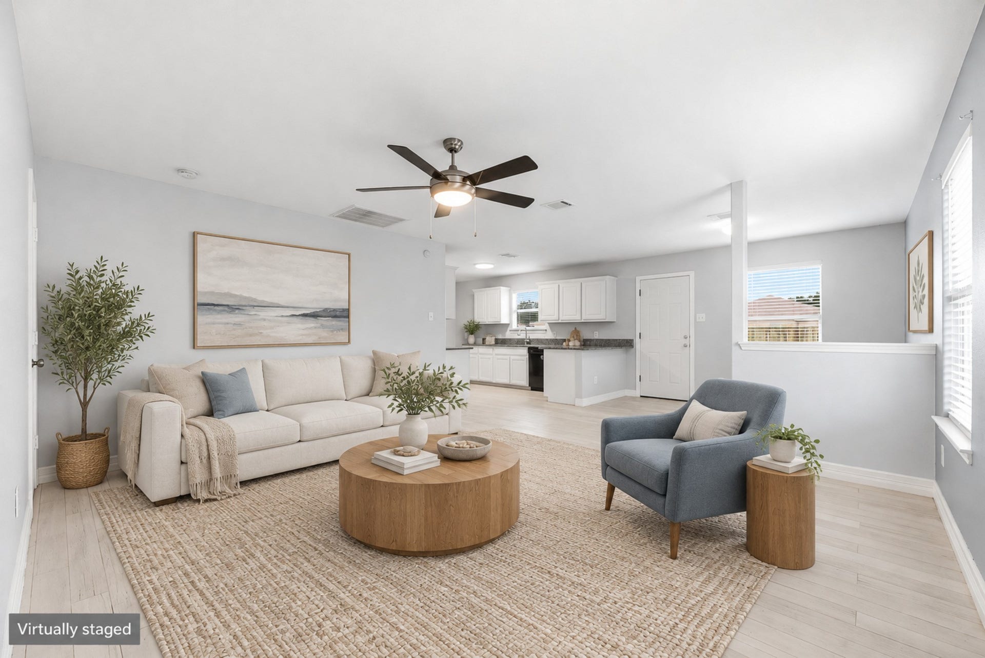 28838 Frio River Loop, Spring, TX 77386 Living area features wood-look flooring, natural light, and an open connection to the kitchen. (Virtually staged)