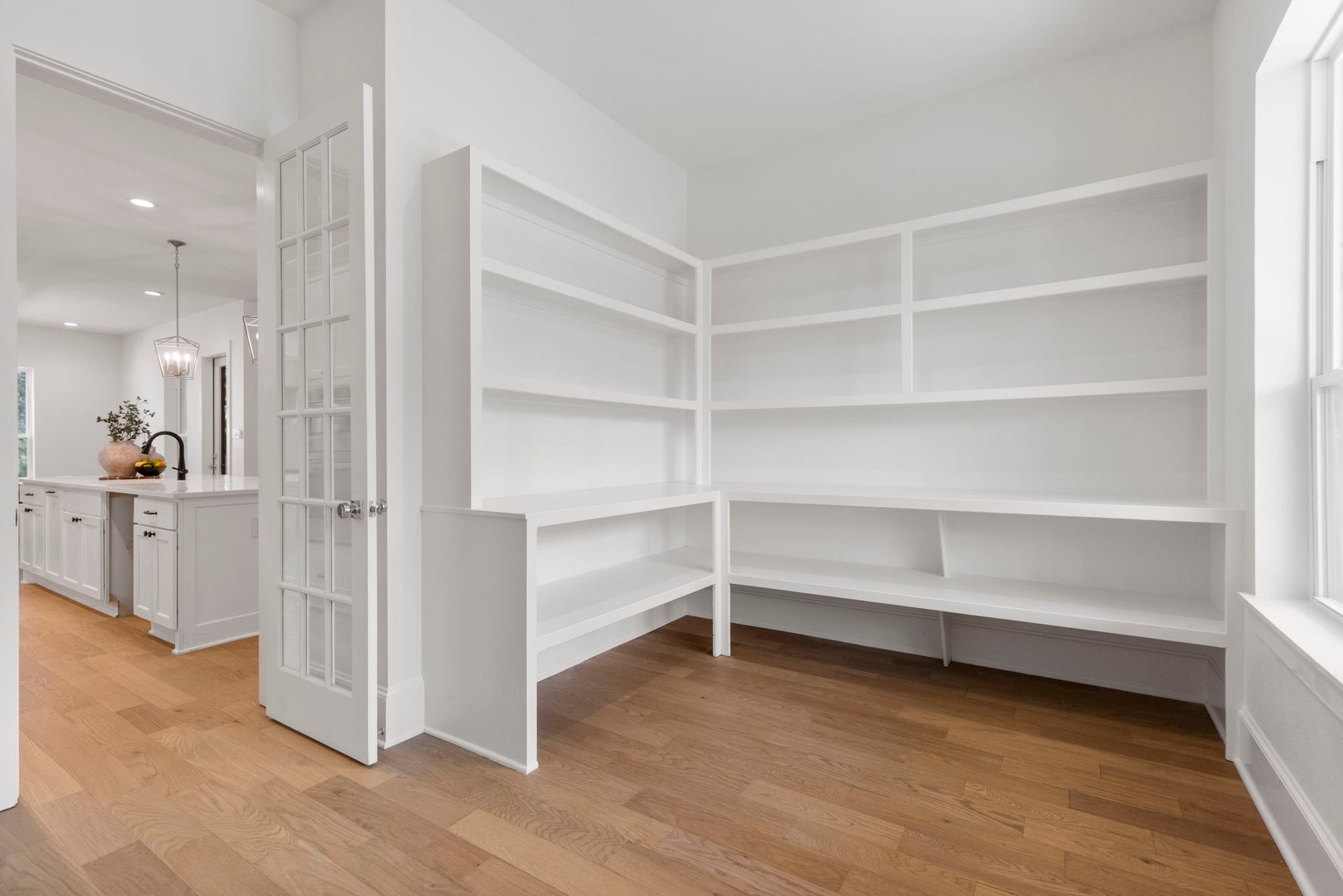 Dream pantry featuring spacious, custom shelving of varying depths, designed for optimal organization and dedicated storage for small appliances.