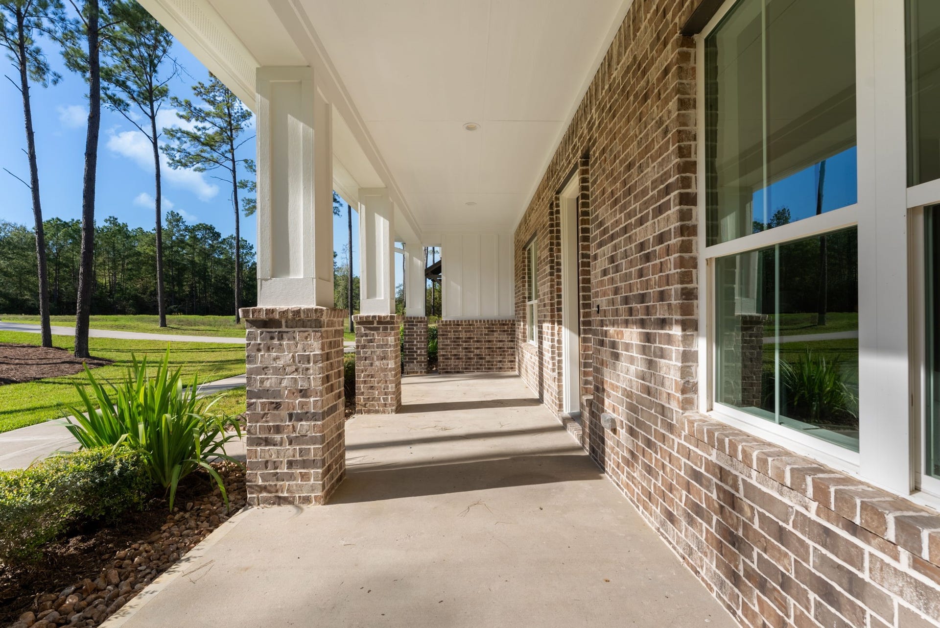 This expansive front porch adds a warm, welcoming charm to the home, perfect for relaxing while overlooking the gorgeous yard.