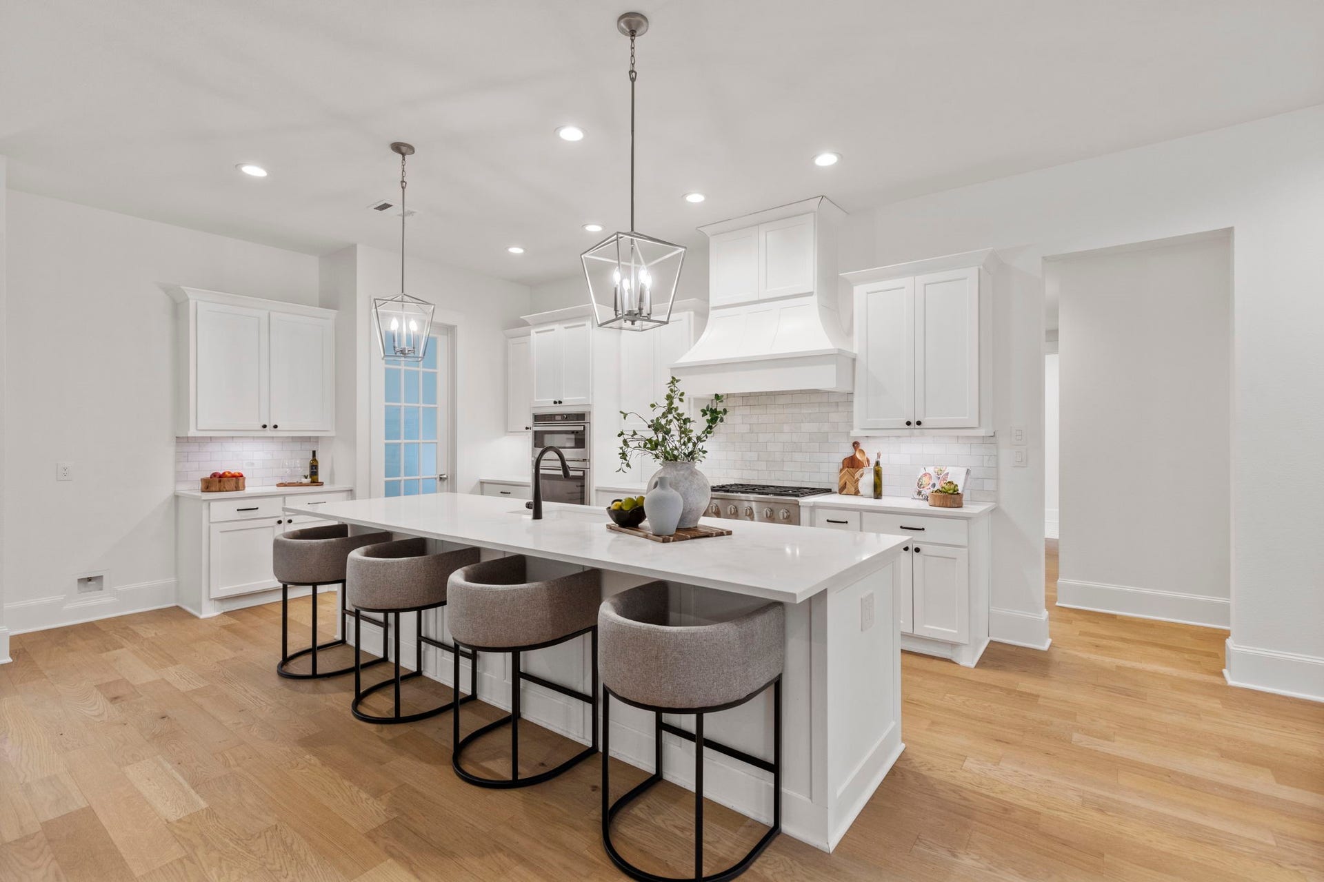 This stunning kitchen features a central island with gorgeous quartz countertops, elegant pendant lighting, and ample seating space perfect for casual dining.
