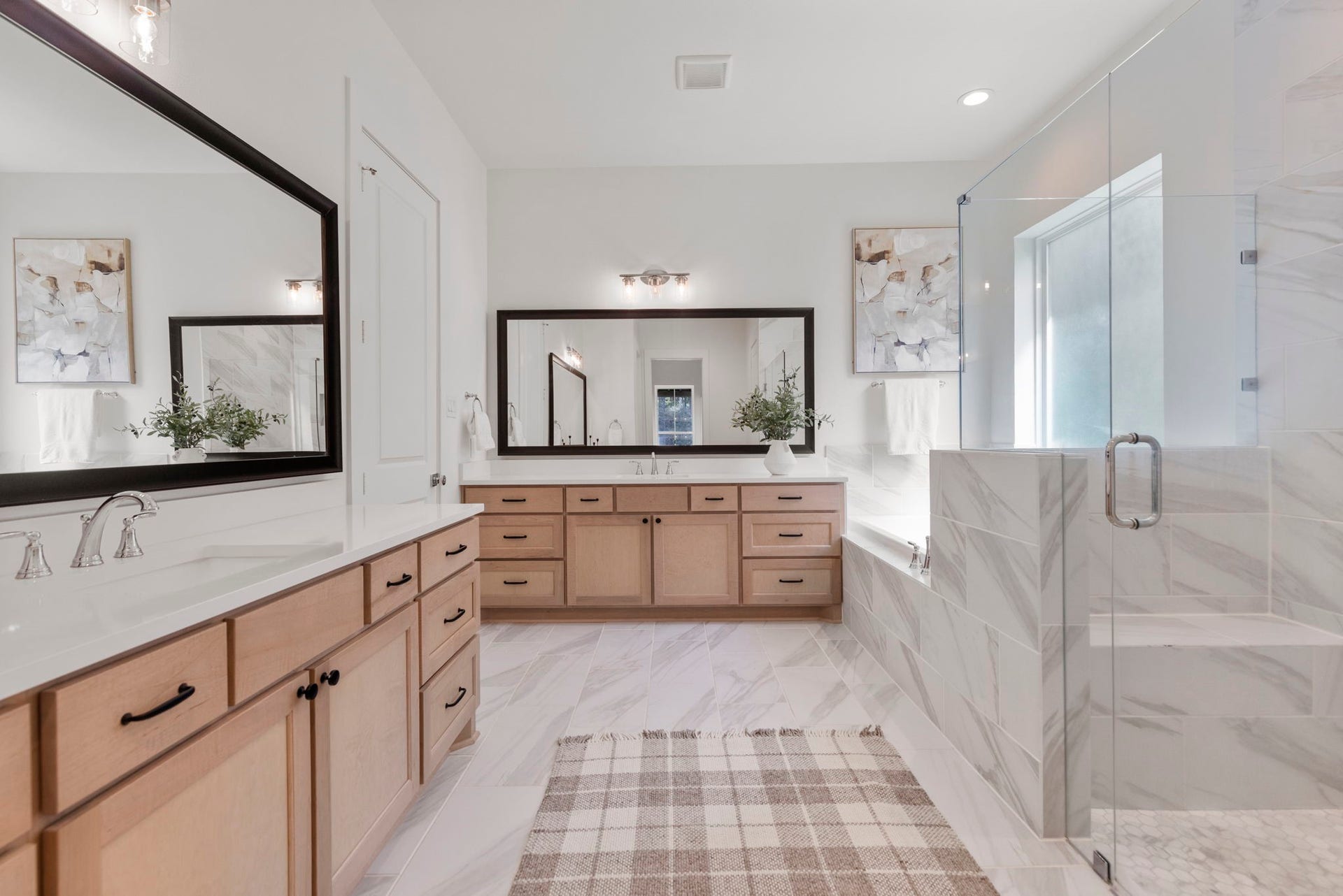 Fabulous primary ensuite featuring upscale finishes, dual vanities, a luxurious soaking tub, and a spacious walk-in glass shower.