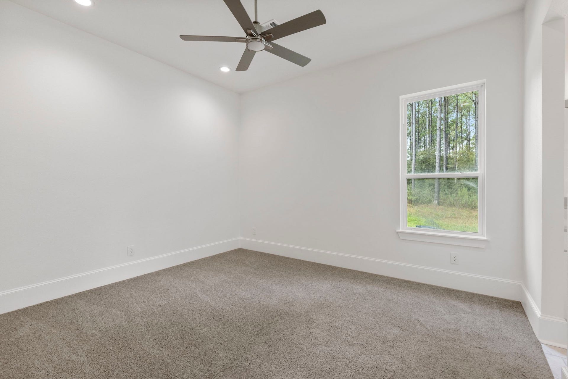 Bedroom three is spacious with beautiful views of trees, and has a convenient ensuite bath.
