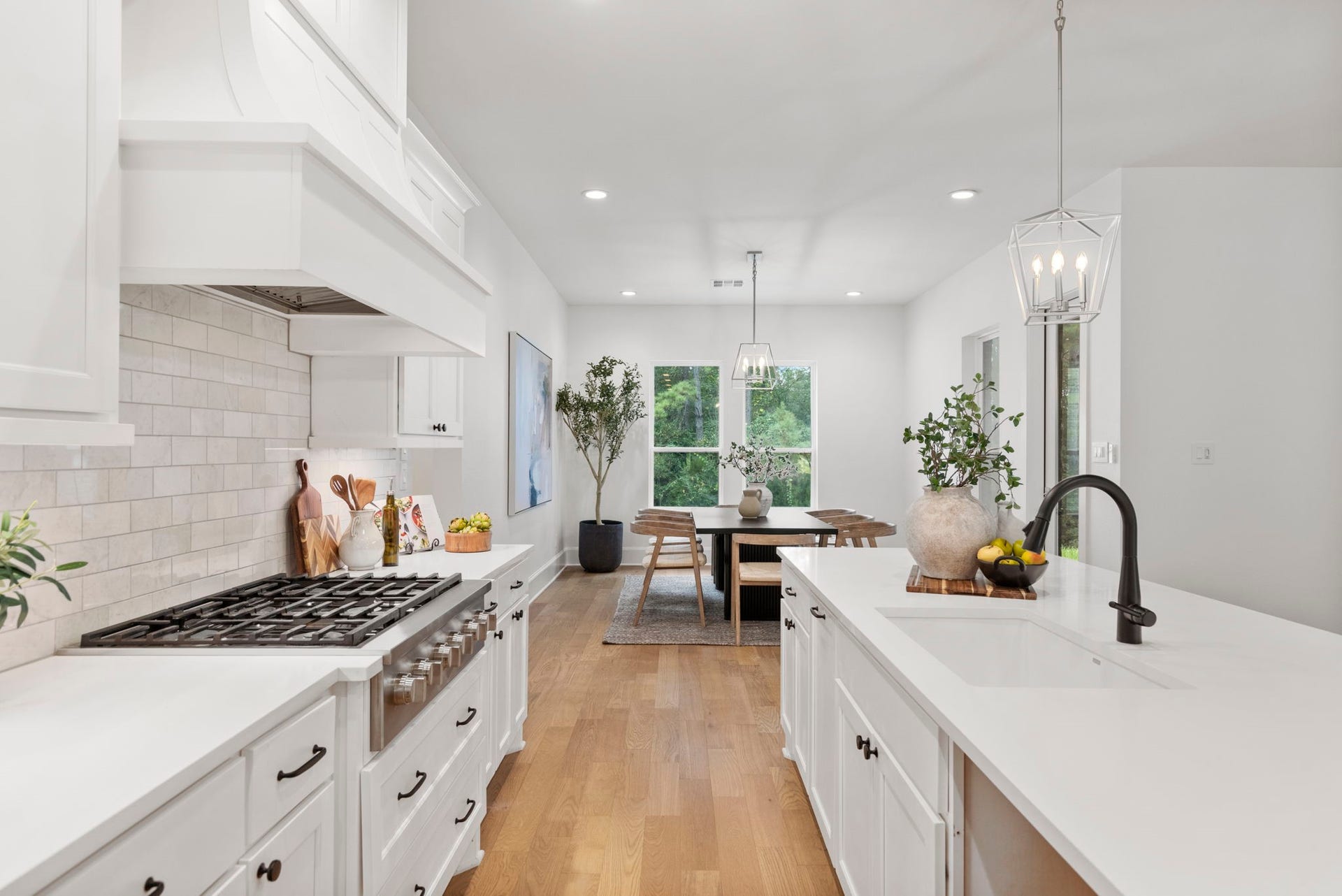 Professional gourmet kitchen featuring a high-end, 6-burner gas cooktop with a sleek, concealed vent hood.