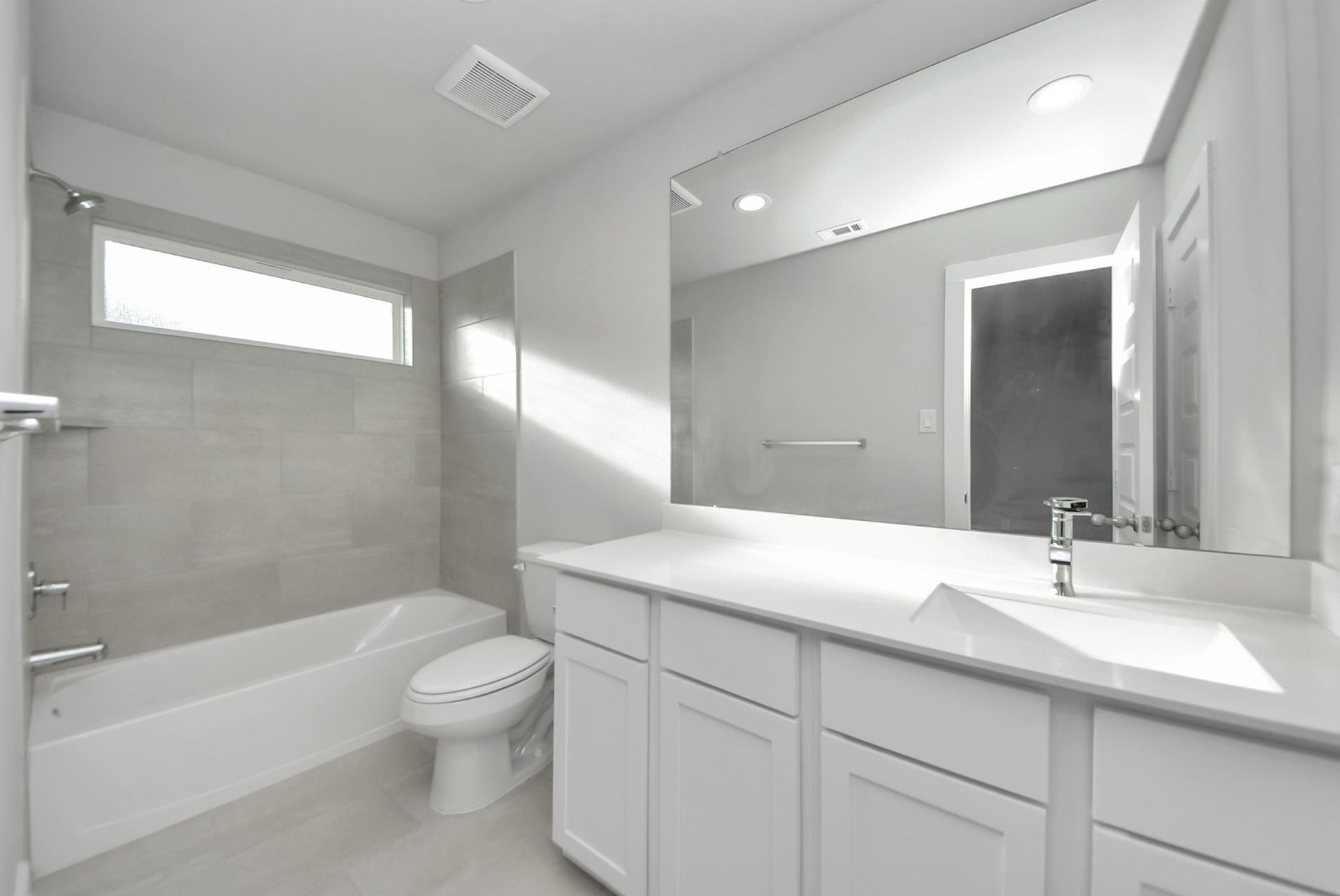 15111 Statice Trail, Houston, TX 77044 Secondary bath features tile flooring, bath/shower combo with tile surround, light stained wood cabinets, beautiful light countertop.